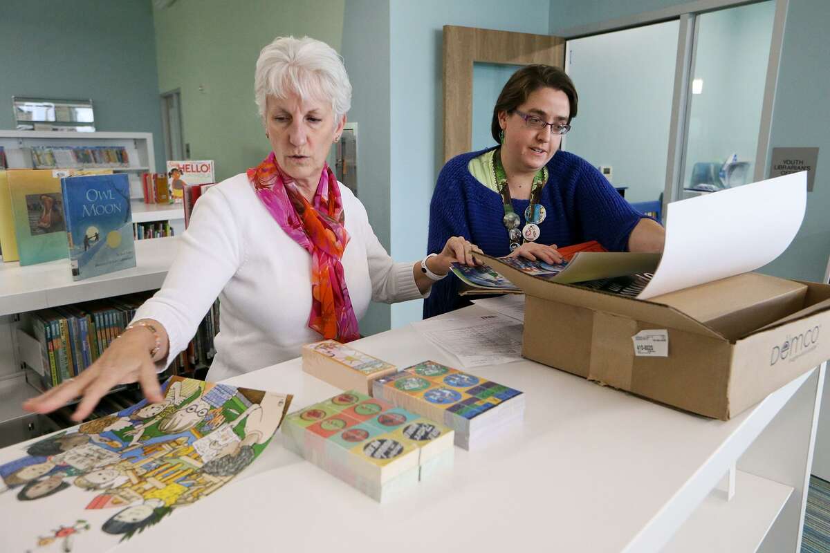 Library clerk Cindy Patterson (left) and youth librarian Jessica Pollock open a box of posters for summer reading programs at the Universal City Public Library, 100 Northview, on Thursday, Jan. 5, 2017, while preparing for the library's grand opening celebration on Jan. 14. MARVIN PFEIFFER/ mpfeiffer@express-news.net