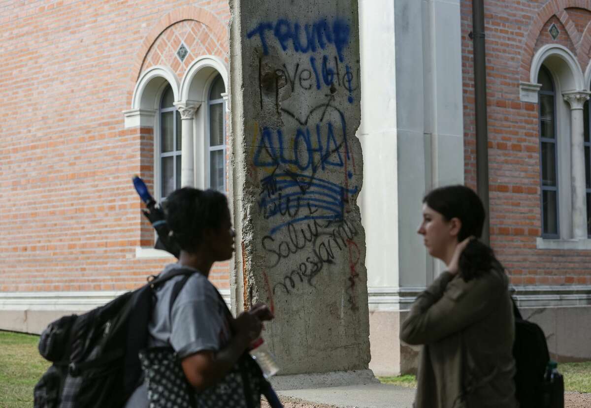 Marred Dr. Lynette Bryant, left, and Amanda Thomas have a conversation in front of the vandalized Berlin Wall memorial outside Rice University Baker Institute for Public Policy on Friday, January 13, in Houston. The wall was vandalized with spray paint graffiti reading "Trump 16" and "Aloha!" (Yi-Chin/ Houston Chronicle)
