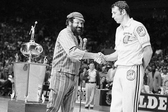 Warriors owner Franklin Mieuli shakes the hand of Jeff Mullins after the team's playoff victory over the Bullets at the Cow Palace near San Francisco. May 23, 1975.