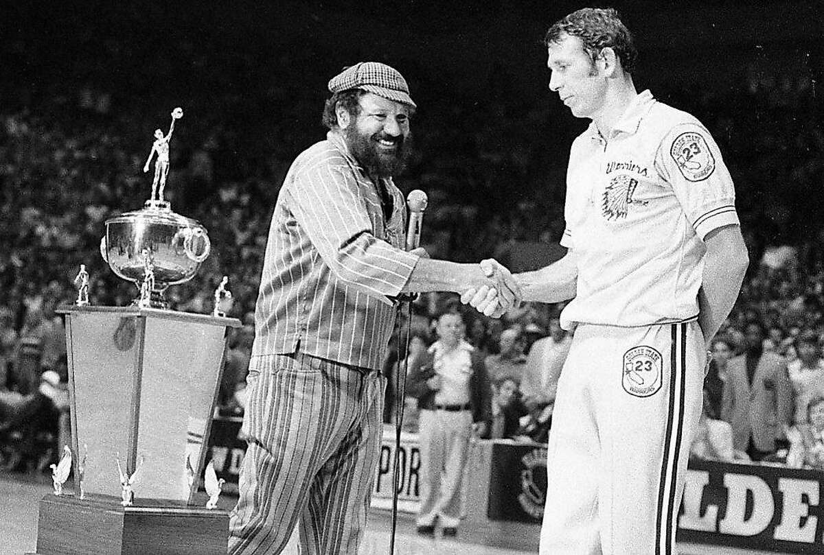 Warriors owner Franklin Mieuli shakes the hand of Jeff Mullins after the team's playoff victory over the Bullets at the Cow Palace in 1975.