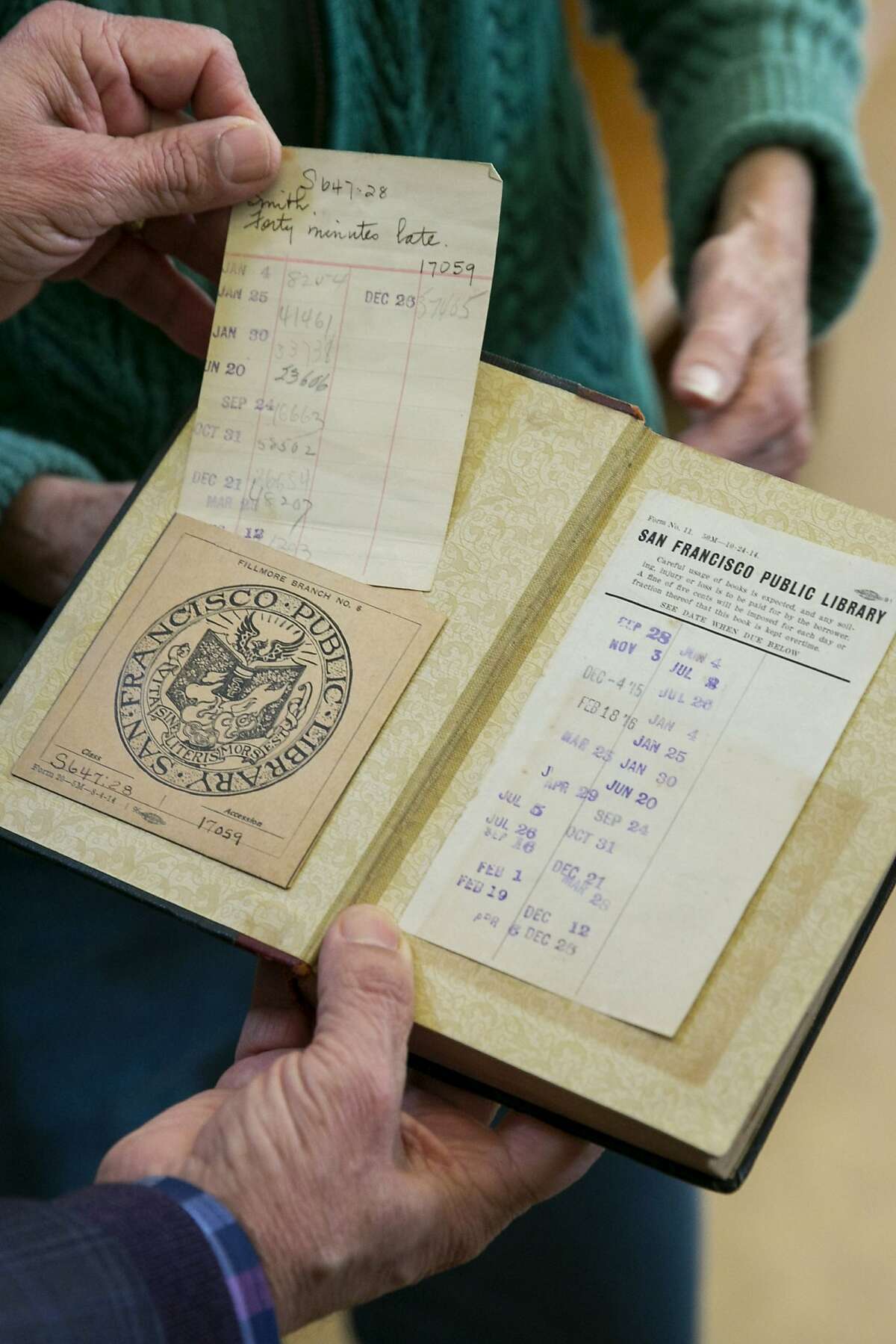 City Librarian Luis Herrera examines the book "Forty Minutes Late" at the San Francisco Public Library Park Branch on Friday, Jan. 13, 2017 in San Francisco, Calif. It was returned today during the library's Fine Forgiveness Program. The book has a 1917 due-date stamp.