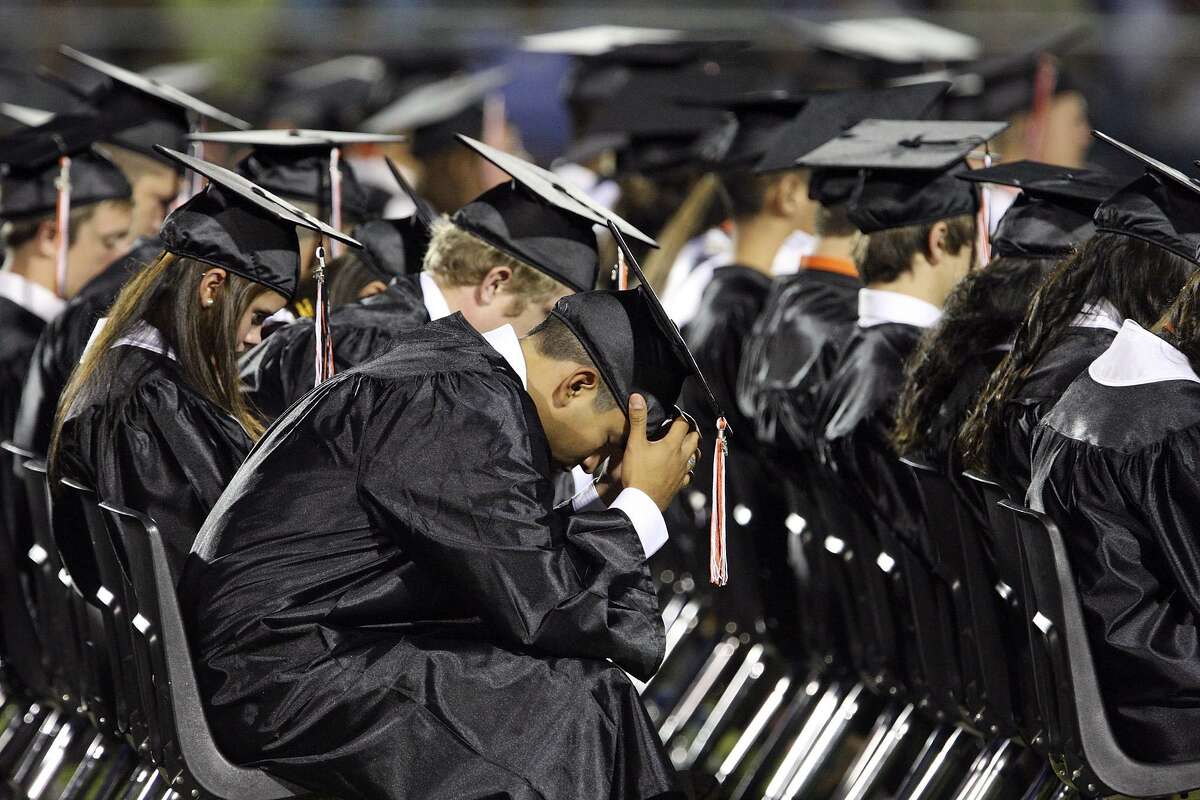 Medina Valley High School graduates take part in a prayer lead by valedictorian Angela Hildenbrand (not pictured) during the Medina Valley High School graduation held in 2011 at Panther Stadium in Castroville, Tx. It will take more than prayer for many Texas high school students to reach graduation day. The state in particular isn’t stepping up.