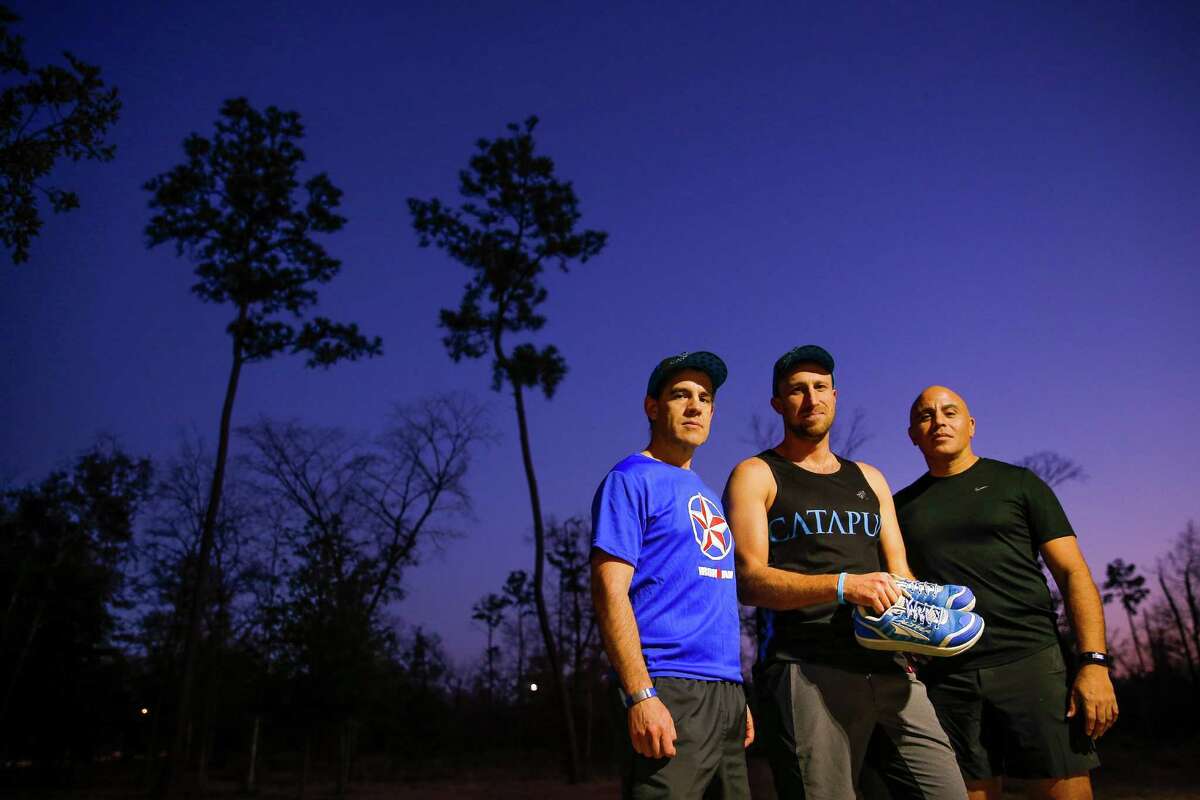 Catapult guide Claudio Bravo, left, president Chris McClendon, center, and guide Samuel Lopez, who all helped blind runner Robert Peck with his training, stand in Memorial Park with his running shoes Thursday, Jan. 12, 2017 in Houston. Peck was a 22-year-old blind man who died from injuries suffered in a New Year's Day hit-and-run. Lopez was planning to run the half marathon side-by-side with Peck, but will now run it alone, carrying Peck's shoes. ( Michael Ciaglo / Houston Chronicle )
