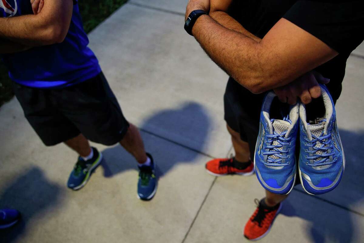 Samuel Lopez, a member of Catapult, a non-profit that helps physically challenged athletes train and race in competitions, holds the running shoes of Robert Peck Thursday, Jan. 12, 2017 in Houston. Peck was a 22-year-old blind man who died from injuries suffered in a New Year's Day hit-and-run. Lopez was planning to run the half marathon side-by-side with Peck, but will now run it alone, carrying Peck's shoes. ( Michael Ciaglo / Houston Chronicle )