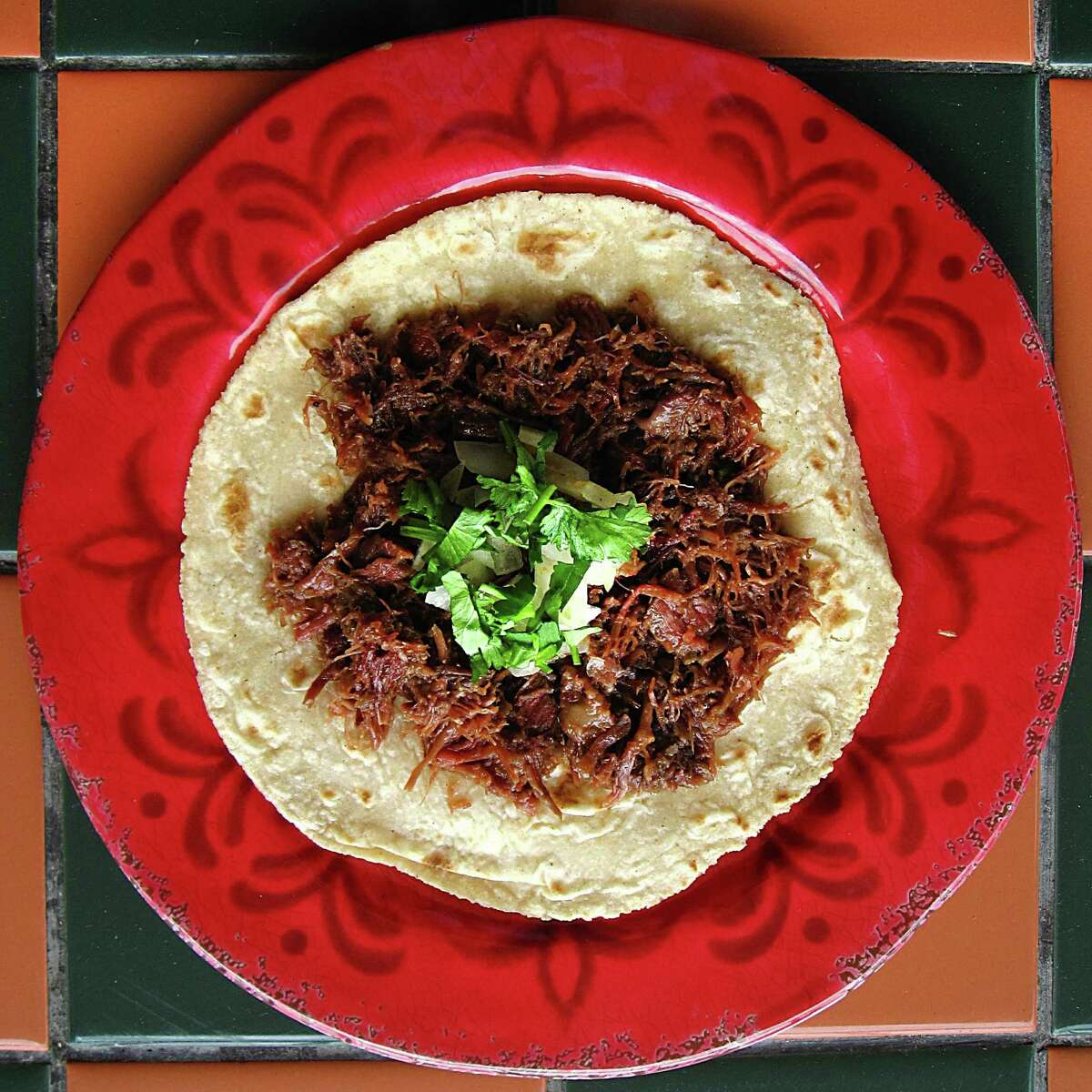 A barbacoa taco on a handmade corn tortilla from El Milagrito Cafe.