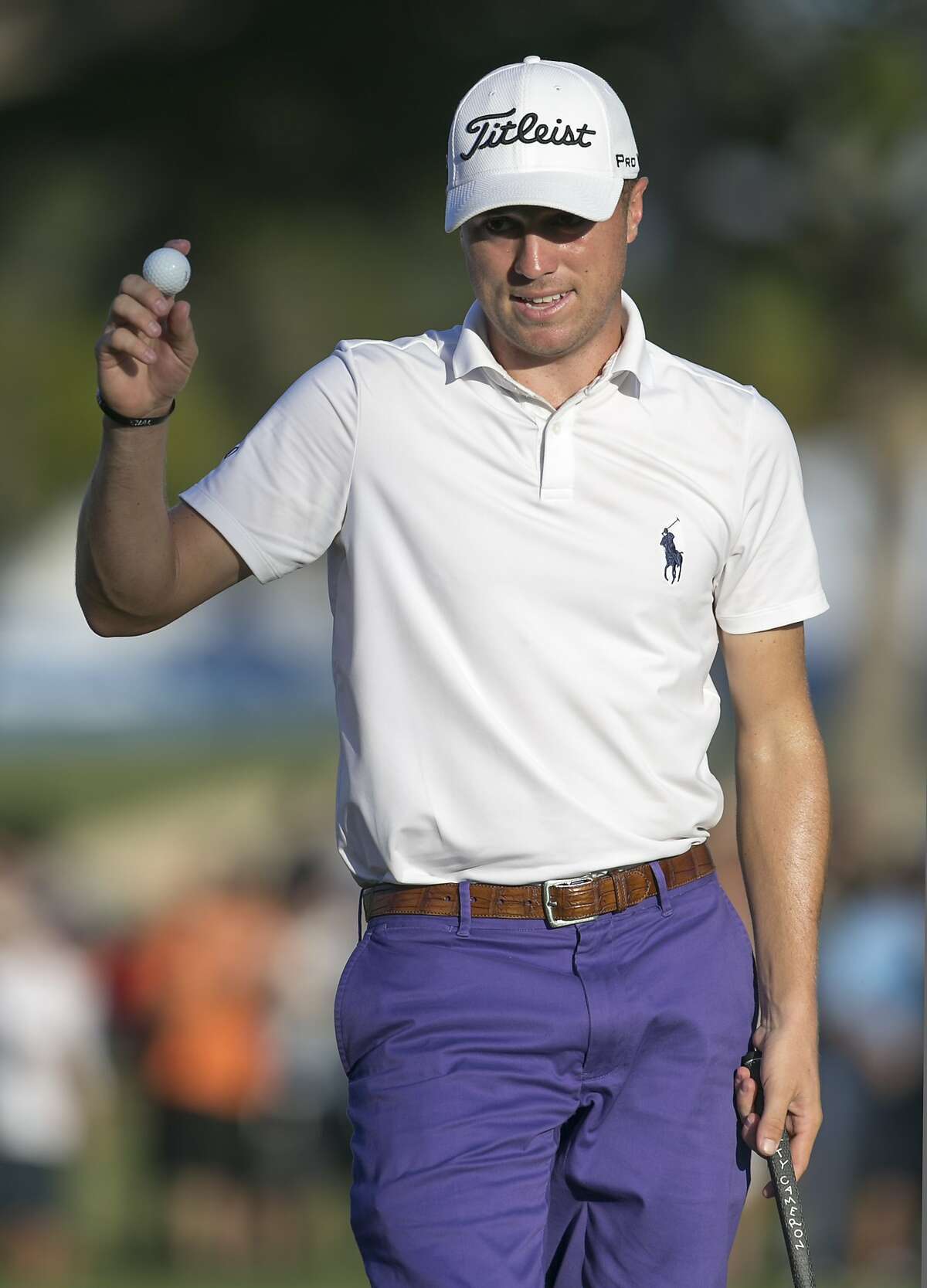 Justin Thomas waves to the gallery on the 18th green after finishing the second round at the Sony Open golf tournament, Friday, Jan. 13, 2017, in Honolulu. (AP Photo/Marco Garcia)