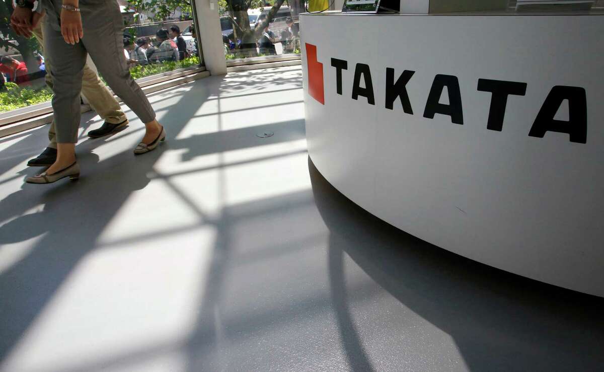 FILE - In this May 4, 2016, file photo, visitors walk by a Takata Corp. desk at an automaker's showroom in Tokyo. The Justice Department is planning to announce a criminal penalty against the Japanese air bag maker as part of its investigation into the company's defective air bag inflators. The department has scheduled a news conference Friday, Jan. 13, 2017 in Detroit to make the announcement. (AP Photo/Shizuo Kambayashi, File)