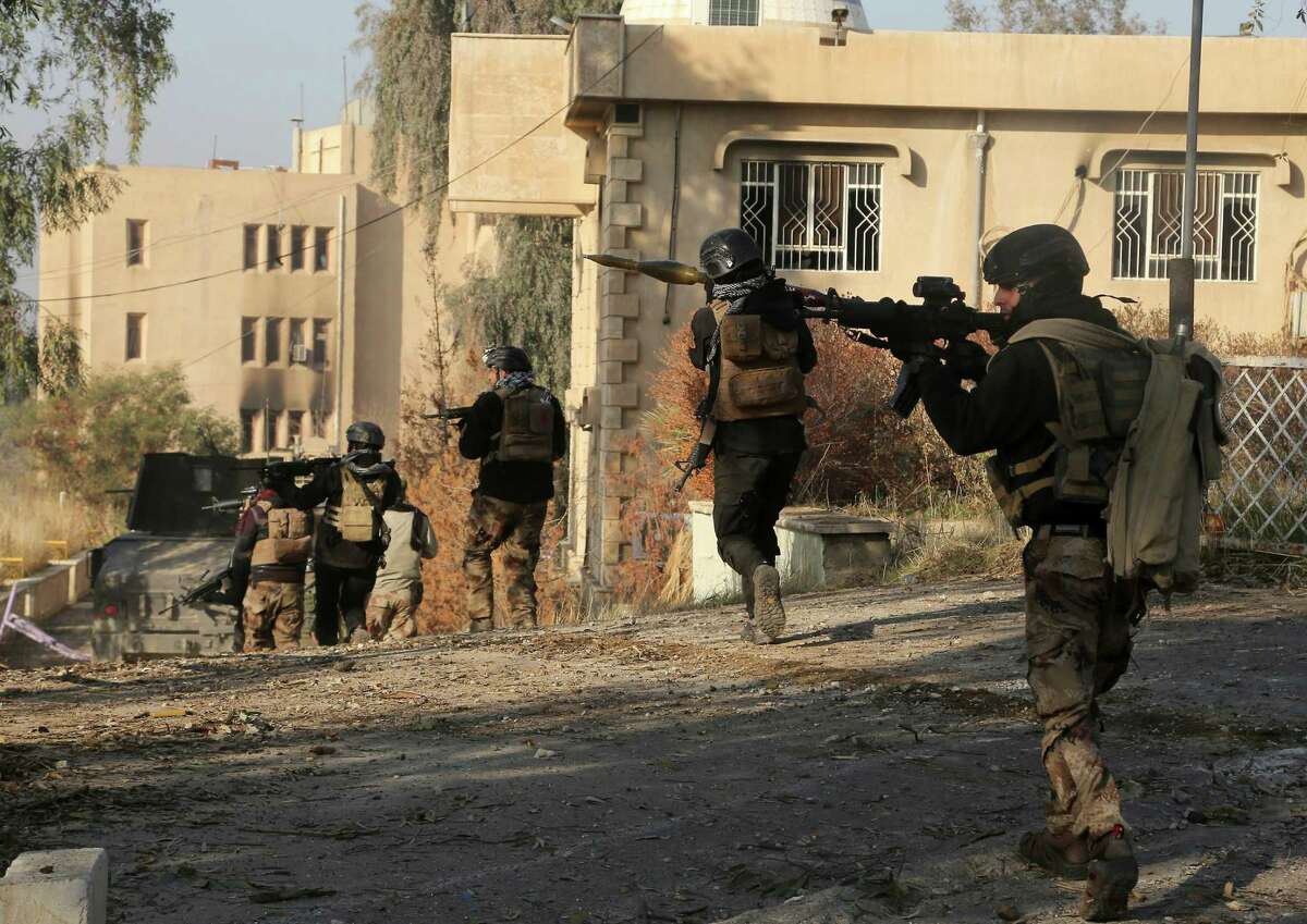 Iraqi special forces advance inside Mosul University grounds during fighting against Islamic State militants in eastern Mosul on Saturday. Commanders said Iraqi forces had secured more than half of the campus.