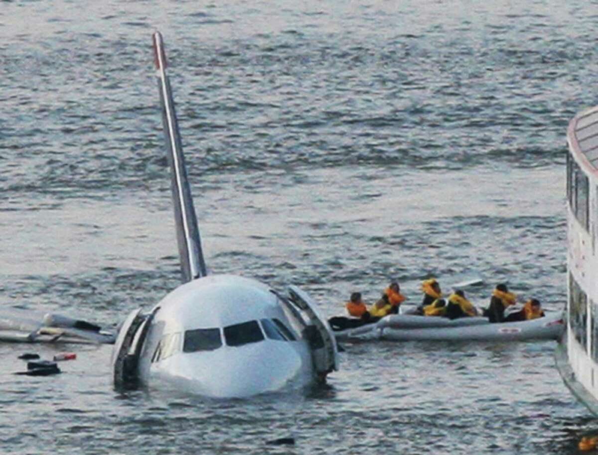 FILE - In this Jan. 15, 2009 file photo, passengers in an inflatable raft move away from an Airbus 320 US Airways aircraft that has gone down in the Hudson River in New York. Eight years after the miracle landing on the Hudson River, thousands of birds have been killed at New York City airports to avoid more strikes. But the slaughter has come at great expense and included many smaller species experts say are unlikely to cause a disaster. (AP Photo/Bebeto Matthews, File)