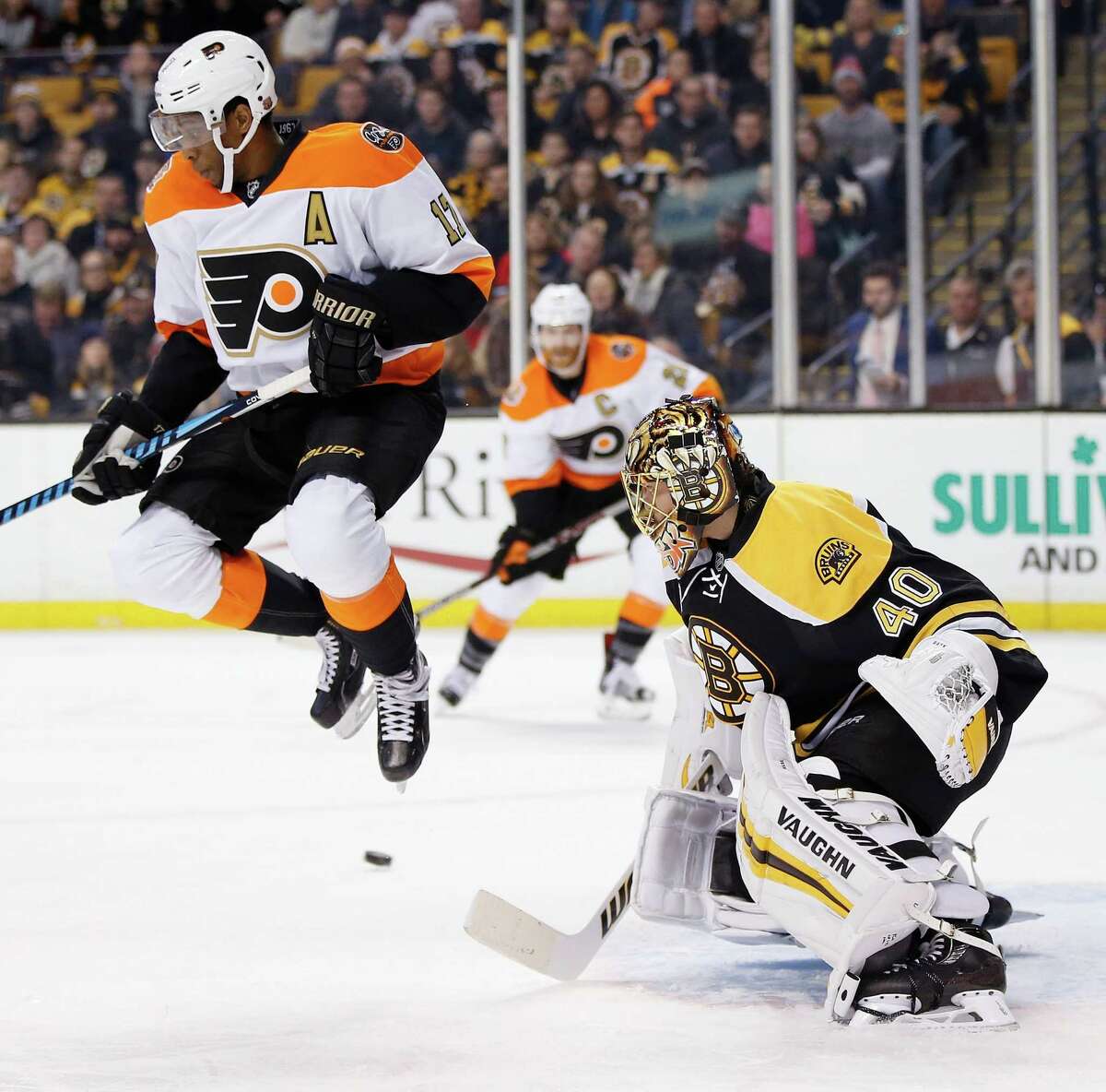 Philadelphia's Wayne Simmonds jumps to avoid a shot on goal while screening Boston's Tuukka Rask, who deflects the puck during the first period of Saturday night's game at Boston.