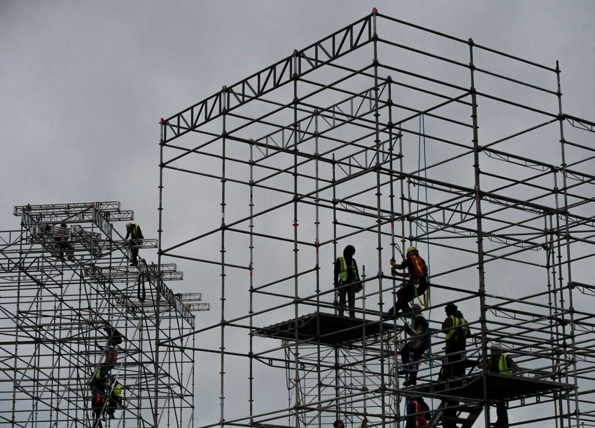 Construction workers climb scaffolding being put up as part of a stage to be used in the presidential inauguration festivities for incoming US President-elect Donald Trump at the Lincoln Memorial in Washington, DC on January 11, 2016. / AFP PHOTO / Andrew CABALLERO-REYNOLDSANDREW CABALLERO-REYNOLDS/AFP/Getty Images