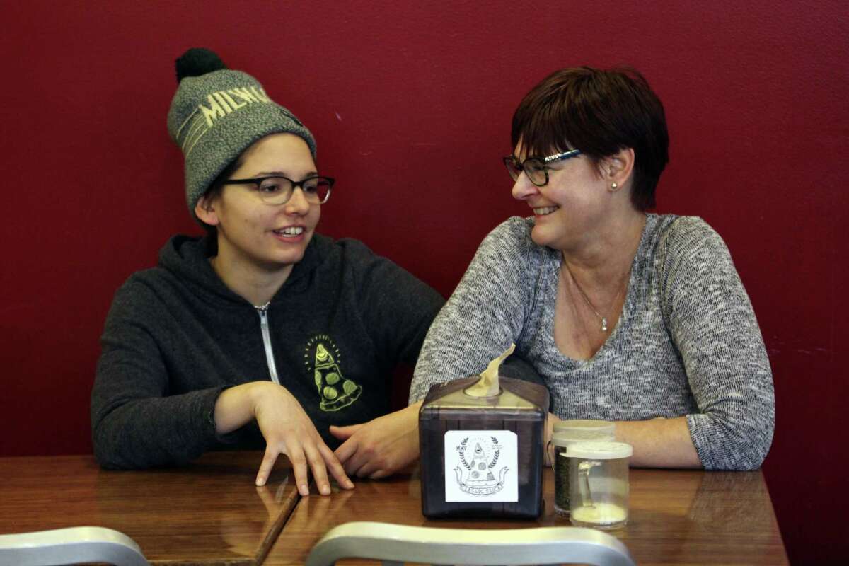 Andrea Ledesma (left) talks with her mother, Cheryl Romanowski, at Classic Slice pizza restaurant, where Ledesma works. Ledesma, 28, says her parents owned a house and were raising kids by her age. Not so for her, even though she has a college degree.