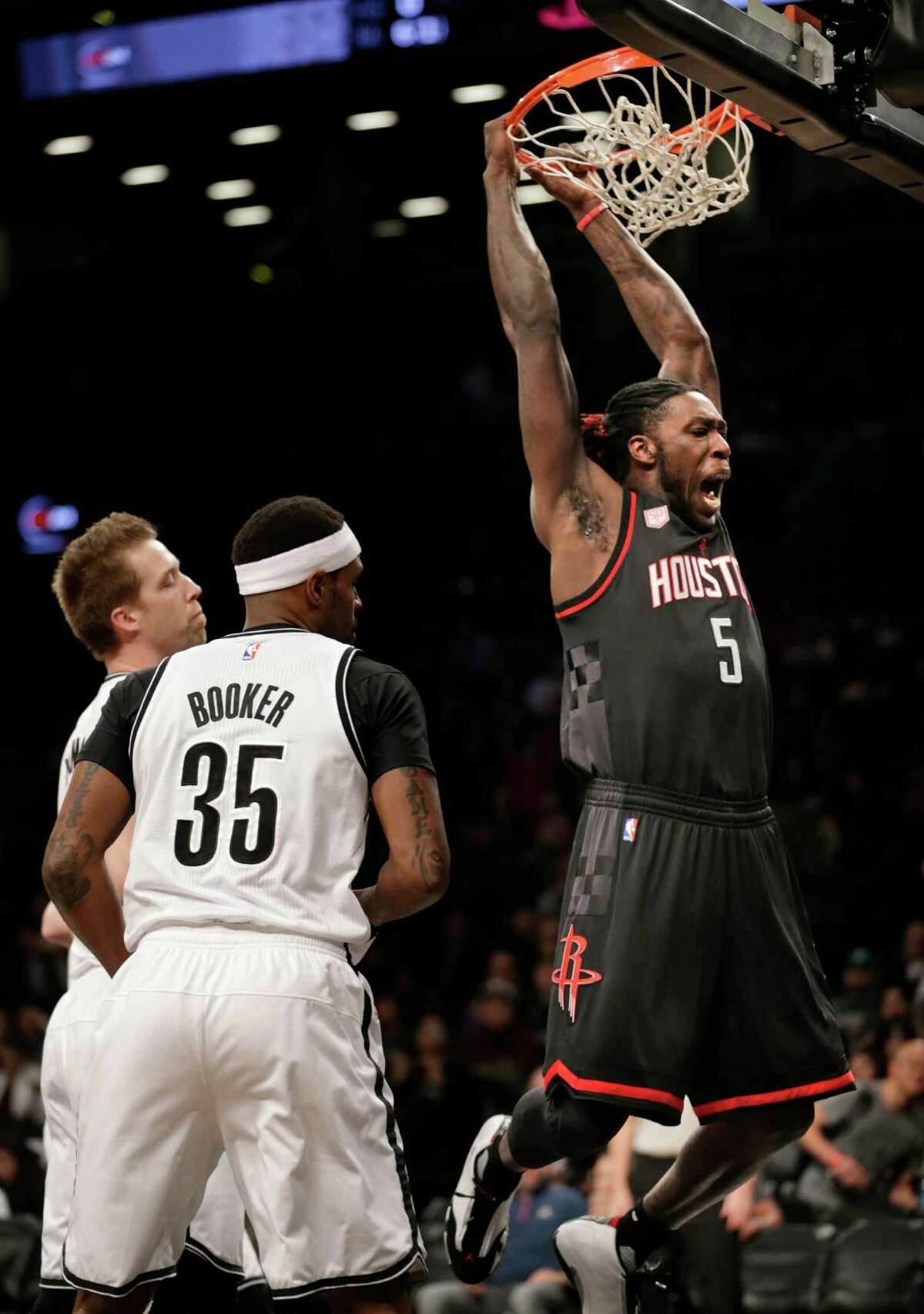 The Rockets' Montrezl Harrell, right, dunks on the Nets' Trevor Booker during the first half for two of his 16 points in the win Sunday at Barclays Center.