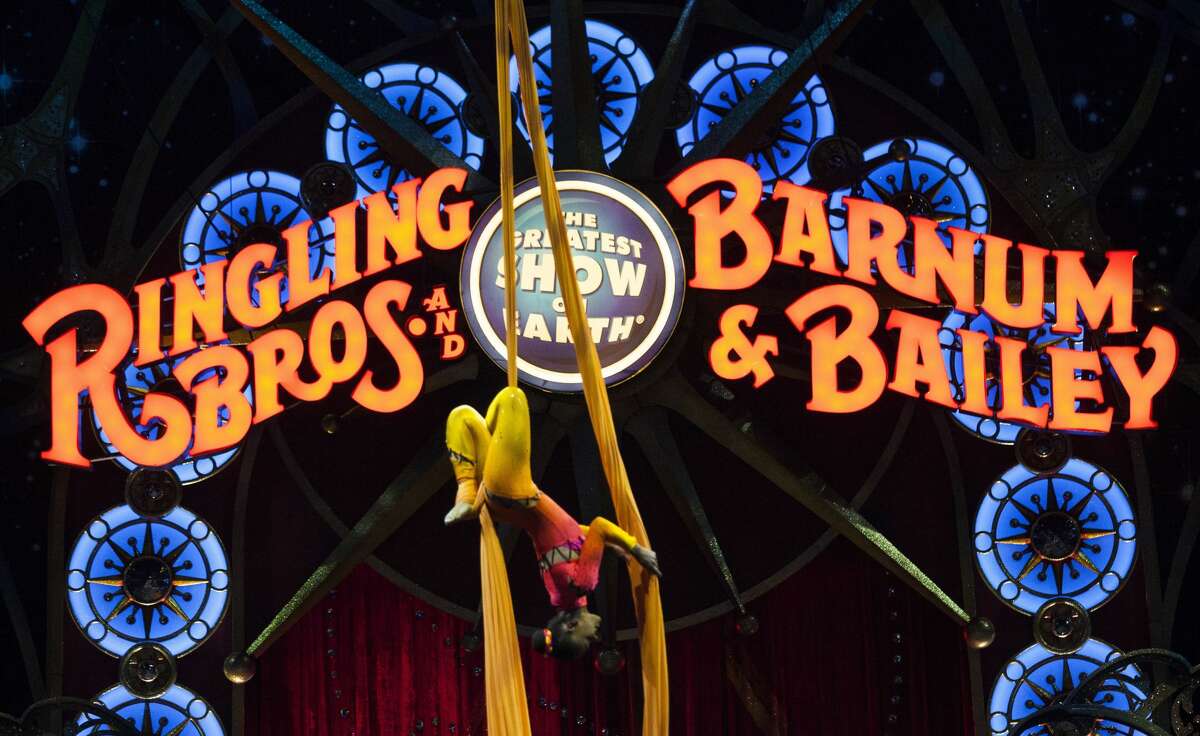 A circus performer hangs upside down during a Ringling Bros. and Barnum & Bailey Circus performance in Washington, DC on March 19, 2015. Across America through the decades, children of all ages delighted in the arrival of the circus, with its retinue of clowns, acrobats and, most especially, elephants. But, bowing to criticism from animal rights groups, the Ringling Bros. and Barnum & Bailey Circus announced on March 5, 2015, it will phase out use of their emblematic Indian stars. (Photo credit should read Andrew Caballero-Reynolds/AFP/Getty Images)