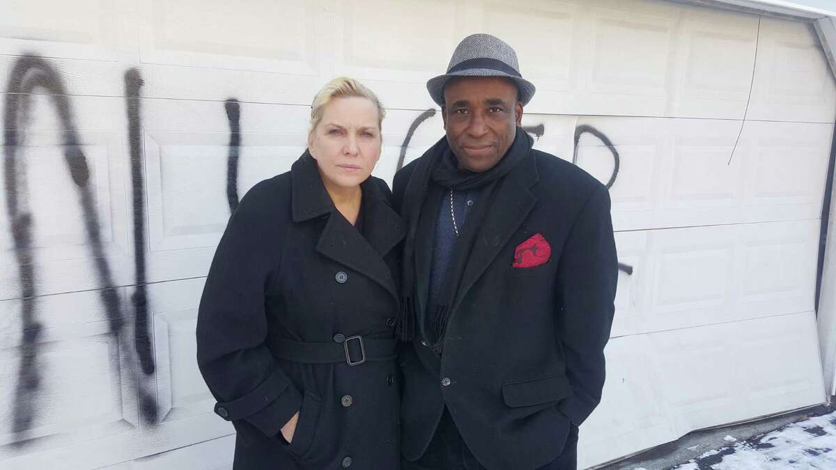 Heather Lindsay and her common-law husband Lexene Charles in front of the garage door of their Bull’s Head residence that was vandalized with a racial slur sometime early Saturday morning in Stamford.