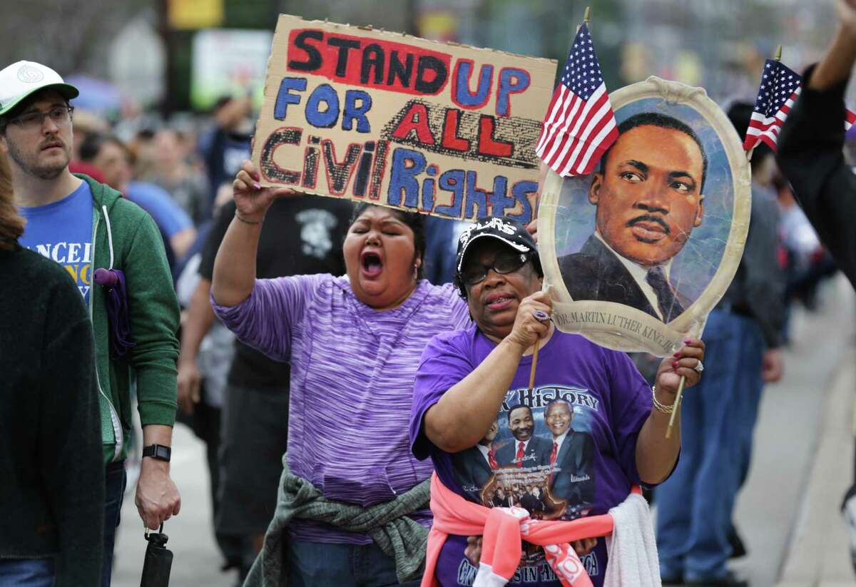 Robbie Thompson carries a poster of Martin Luther King, one she’s kept for years, at the 30th annual march.