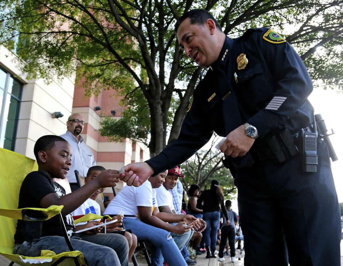 Houston Police Chief of Police Art Acevedo right, hands a sticker to Deon Hudson left, during the Black Heritage Society's 39th Annual MLK, Jr. Parade Monday, Jan. 16, 2017, in Houston.