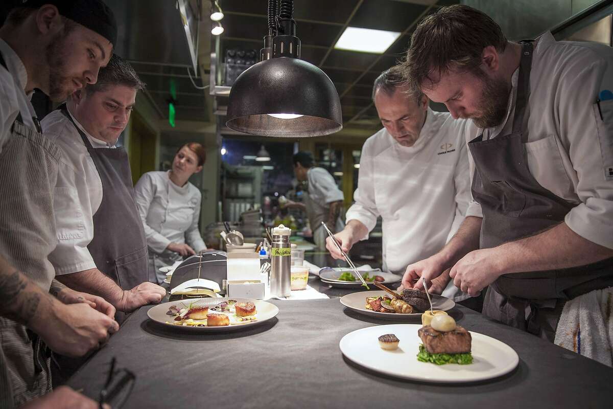 Dry Creek Kitchen executive chef Scottie Romano (left rear), Chef Charlie Palmer (right rear) line cook Michael Cochren (left front) and Sous chef Kyle Buchanan (right front) peeping plate during service, Saturday January, 07 2017 in Healdsburg, CA. (Peter DaSilva Special to the Chronicle)