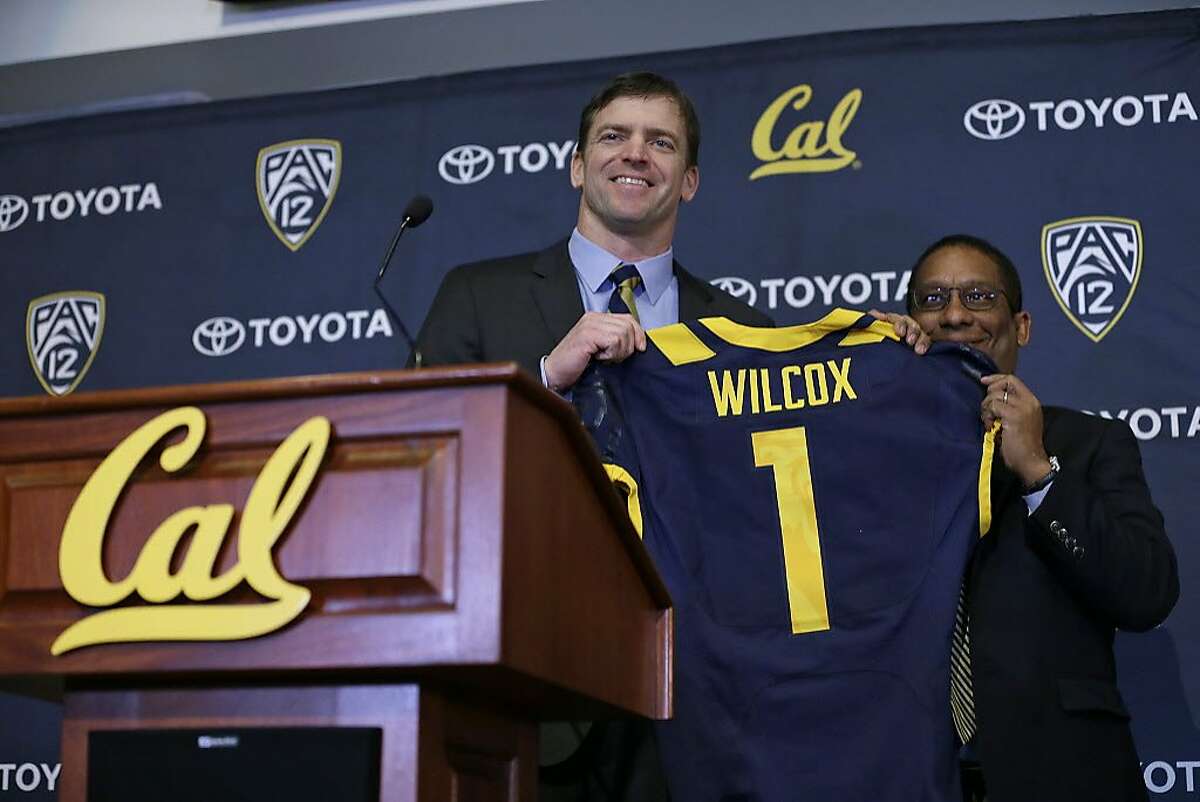 California head football coach Justin Wilcox, left, is presented a jersey by Director of Athletics Mike Williams, right, during a news conference Tuesday, Jan. 17, 2017, in Berkeley, Calif. California officially introduced Wilcox, hoping the long-time defensive coordinator can help revive the struggling program. (AP Photo/Eric Risberg)
