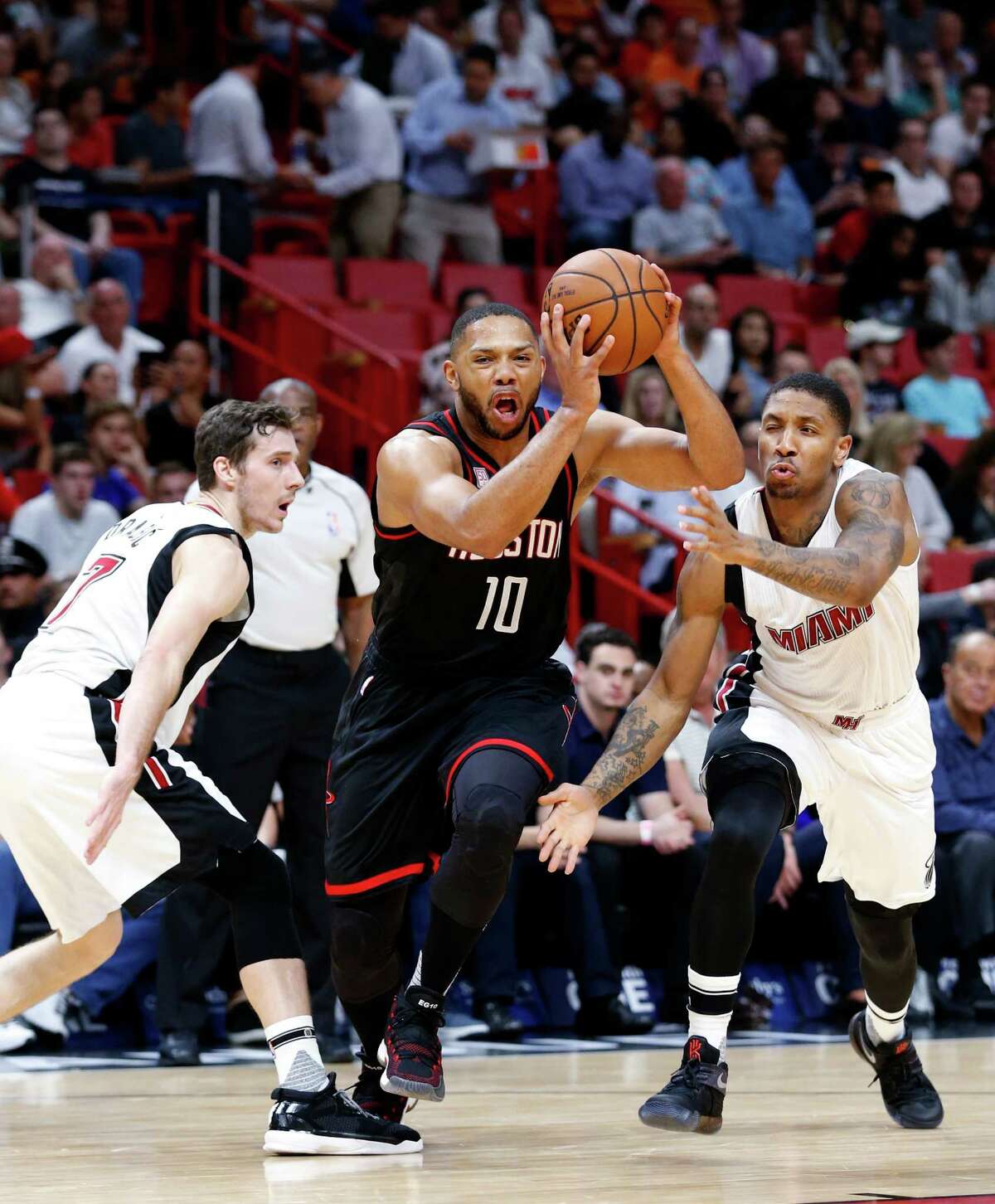 Houston Rockets guard Eric Gordon (10) drives past Miami Heat guard Goran Dragic, left, and guard Rodney McGruder during the first half of an NBA basketball game, Tuesday, Jan. 17, 2017, in Miami. (AP Photo/Wilfredo Lee)