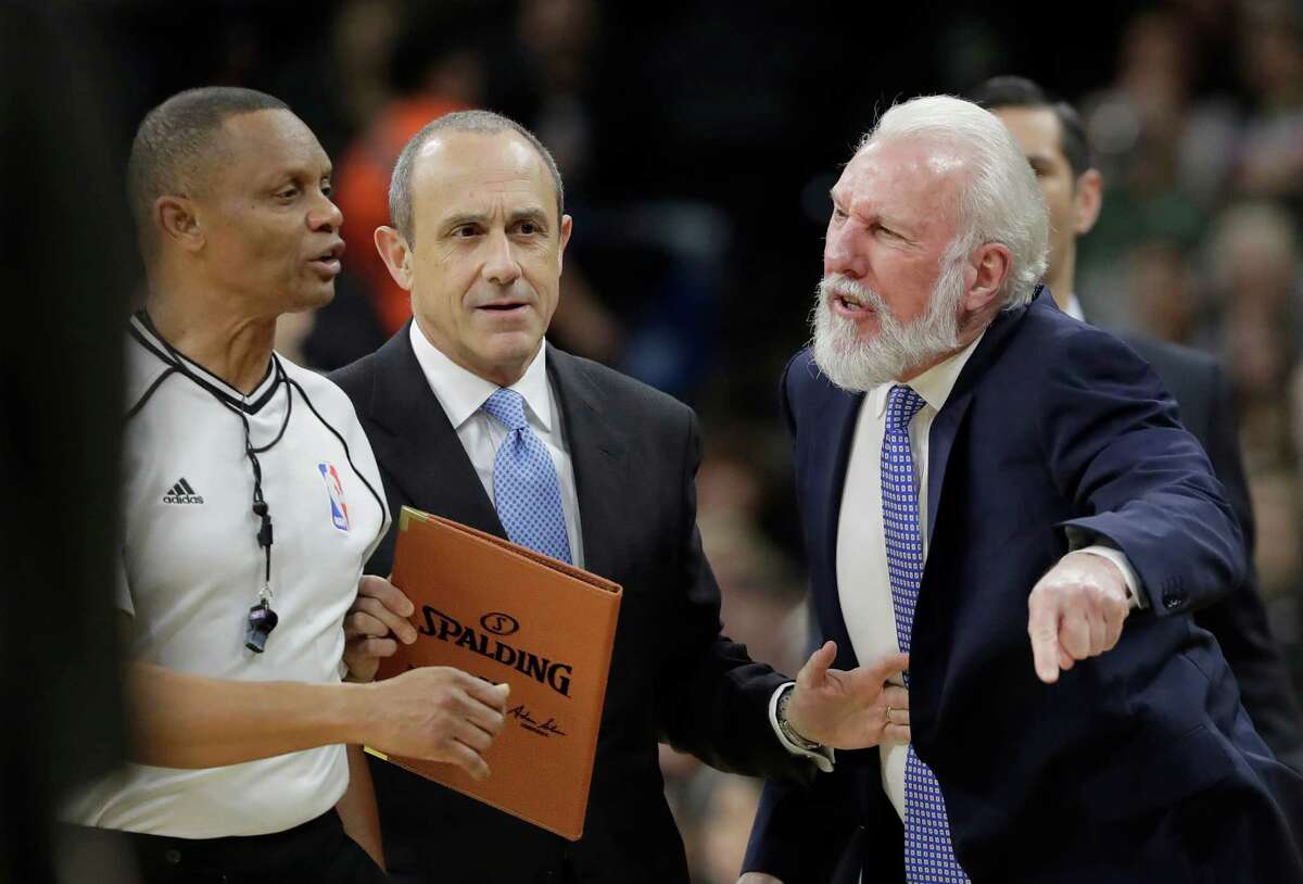 San Antonio Spurs coach Gregg Popovich, right, is held back from referee Michael Smith, left, by assistant coach Ettore Messina, center, as he argues a call during the first half of the team's NBA basketball game against the Minnesota Timberwolves, Tuesday, Jan. 17, 2017, in San Antonio. (AP Photo/Eric Gay)