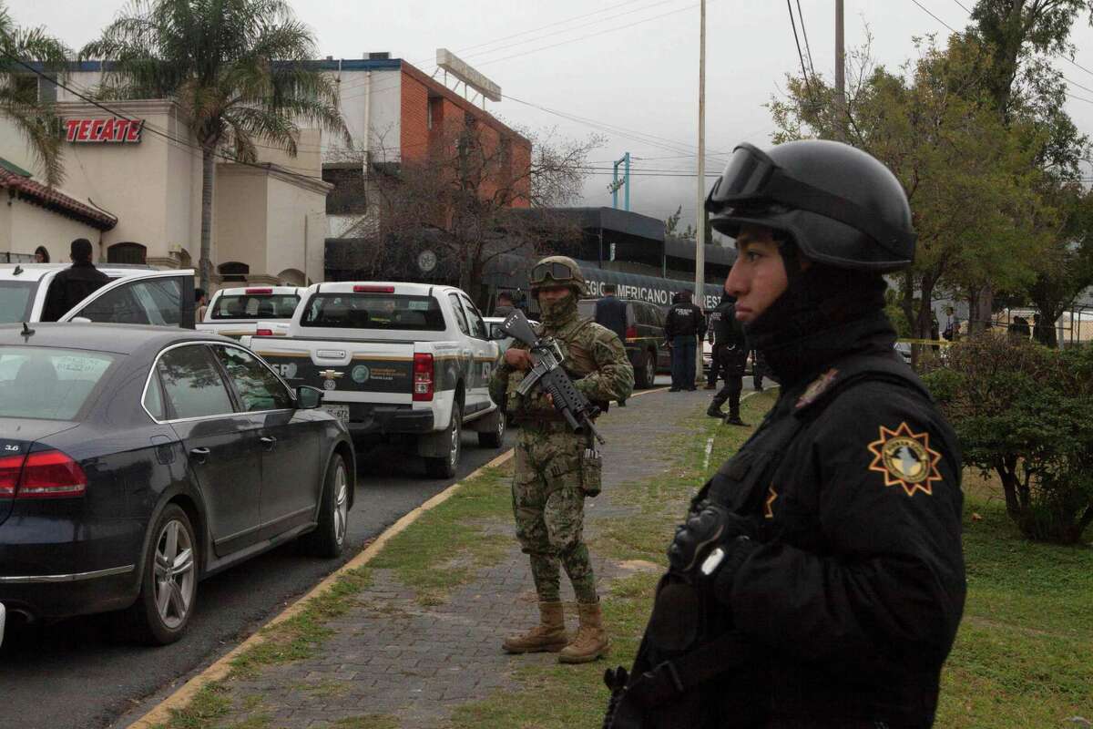 A soldier and a police officer stand guard outside a high school where a student opened fire on his classmates in Monterrey, Mexico, on January 18, 2017. A high school student shot his teammates at a college in Monterrey, an industrial city in northeastern Mexico, in an unprecedented event that left five people injured, including the assailant who attempted suicide, authorities in the state of Nuevo Leon reported. / AFP PHOTO / Julio Cesar AGUILARJULIO CESAR AGUILAR/AFP/Getty Images