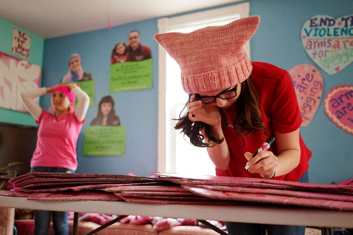 Wearing a "Pussy Hat," first-time activist Emily Jones works on protest signs at the Code Pink House in Washington D.C. office on Wednesday January 18, 2017.