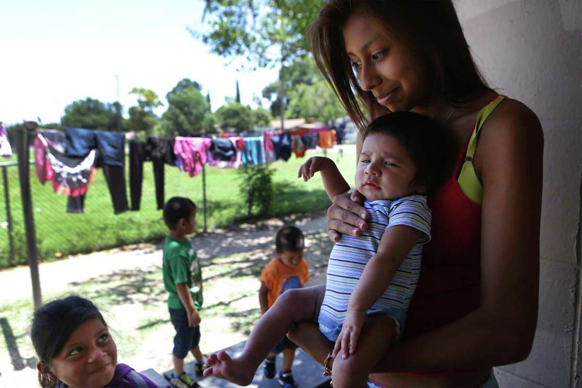 Leann Campos holds her baby, Elijah Gonzalez, that she had with Jason Gonzalez, 15. The couple lives with his mother Anne Ruiz, 36 and 6 other family members in their apartment in Cassiano Homes. Wednesday, July 15, 2015. They have since moved out of the housing project.
