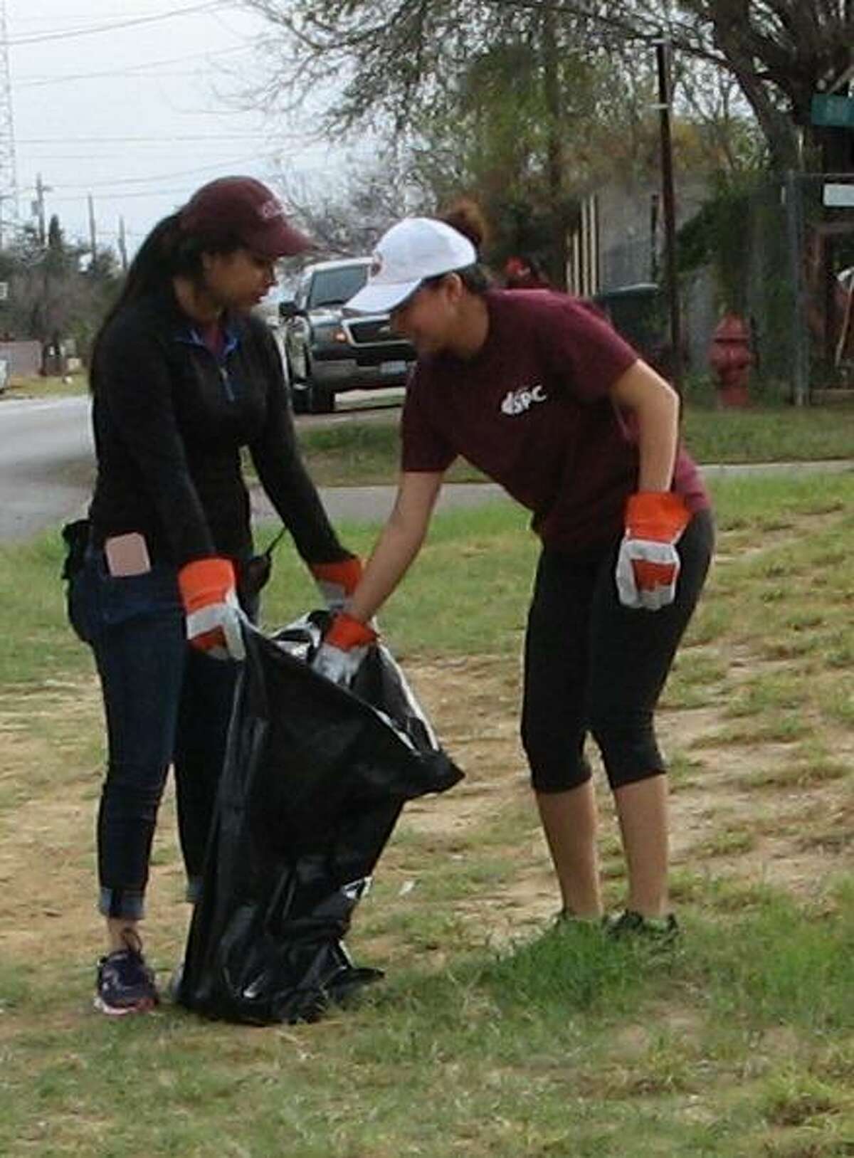 Cassandra Chavez and Dixie Garcia clean up litter along Paseo de Danubio in Rio Bravo.