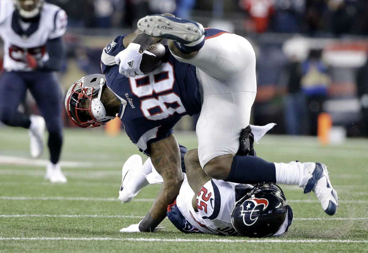 Houston Texans cornerback Kareem Jackson tackles New England Patriots tight end Martellus Bennett (88) during the first half of an NFL divisional playoff game on Jan. 14, 2017, in Foxborough, Mass.