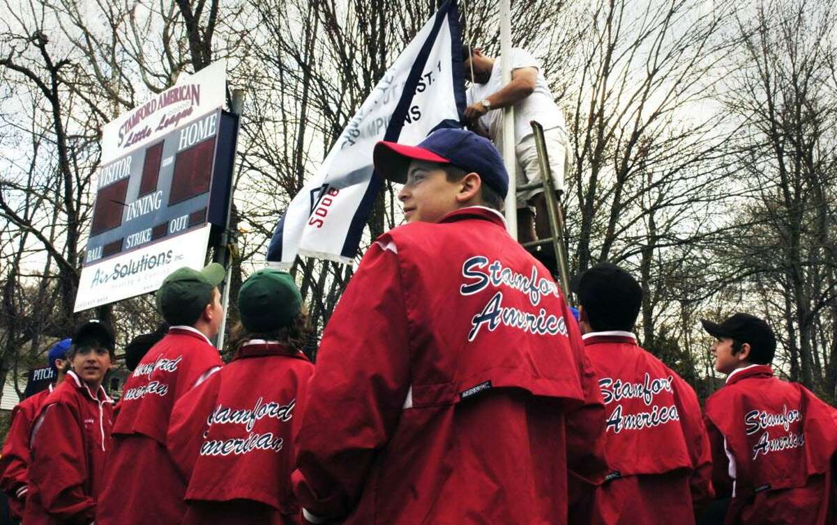 Stamford_042807_The 2006 Stamford American Little League 10-11 All-Stars surround the flagpole at Gene Caporizzo Field as their Connecticut District 1 championship banner is raised during opening day ceremonies. Andrew Sullivan/Staff photo Staff Photo Andrew Sullivan