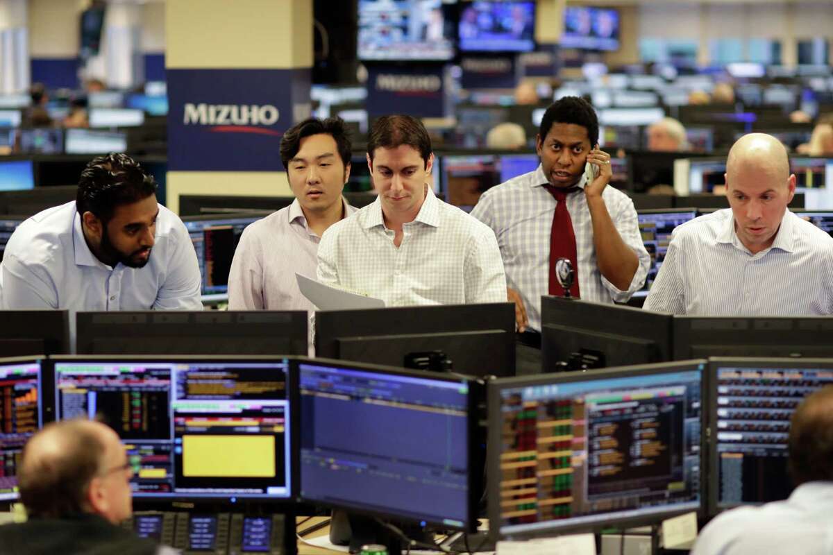 In this Jan. 12, 2017, photo, traders work on the Mizuho Americas trading floor in New York. World stocks were mostly lower Thursday, Jan. 19, ahead of comments from the European Central Bank's president and after Federal Reserve chair Janet Yellen signaled more interest rate increases in the months to come. (AP Photo/Mark Lennihan)
