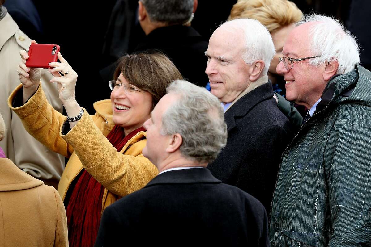 Sen. Amy Klobuchar of Minnesota takes a selfie with Sen. John McCain (R-AZ) and Sen. Bernie Sanders (D-VT) (R) on the West Front of the U.S. Capitol on January 20, 2017 in Washington, DC. In today's inauguration ceremony Donald J. Trump becomes the 45th president of the United States. EDITORS NOTE: This photo was originally published with a Getty Images caption that failed to identify Sen. Klobuchar. SFGATE updated this caption after spotting the photographer's mistake and is reviewing procedures for automatically ingesting captions. We apologize for publishing the original inappropriate caption, and have apologized to Sen. Klobuchar for using the original Getty caption in the first place.