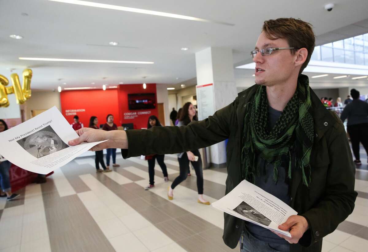 Students for A Democratic Society Coordinator Fabian Sneevliet passes out flyers for a protest against President Donald J. Trump during the inauguration ceremony at the school's watch party at student center on Friday, January 20, in Houston.