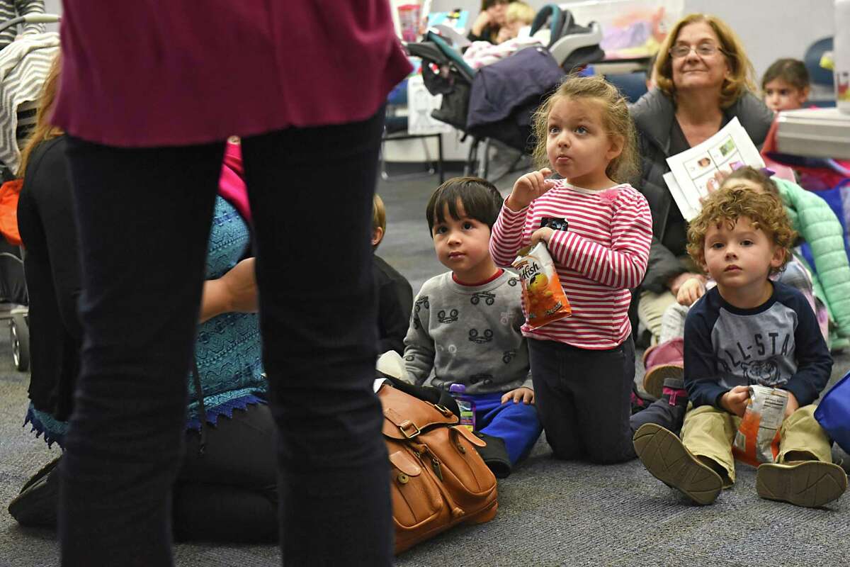 From left, Lou Cicchetti, 3, of Altamont, Amelia Tice, 5, of Guilderland and Maxwell Person, 3, of Slingerlands listen as children's librarian Elisabeth Smith, left, gives instruction on keeping track of the number of books they read during the "All Aboard to 1,000 Books Before Kindergarten!" event at Guilderland Public Library on Friday, Jan. 20, 2017 in Guilderland, N.Y. (Lori Van Buren / Times Union)