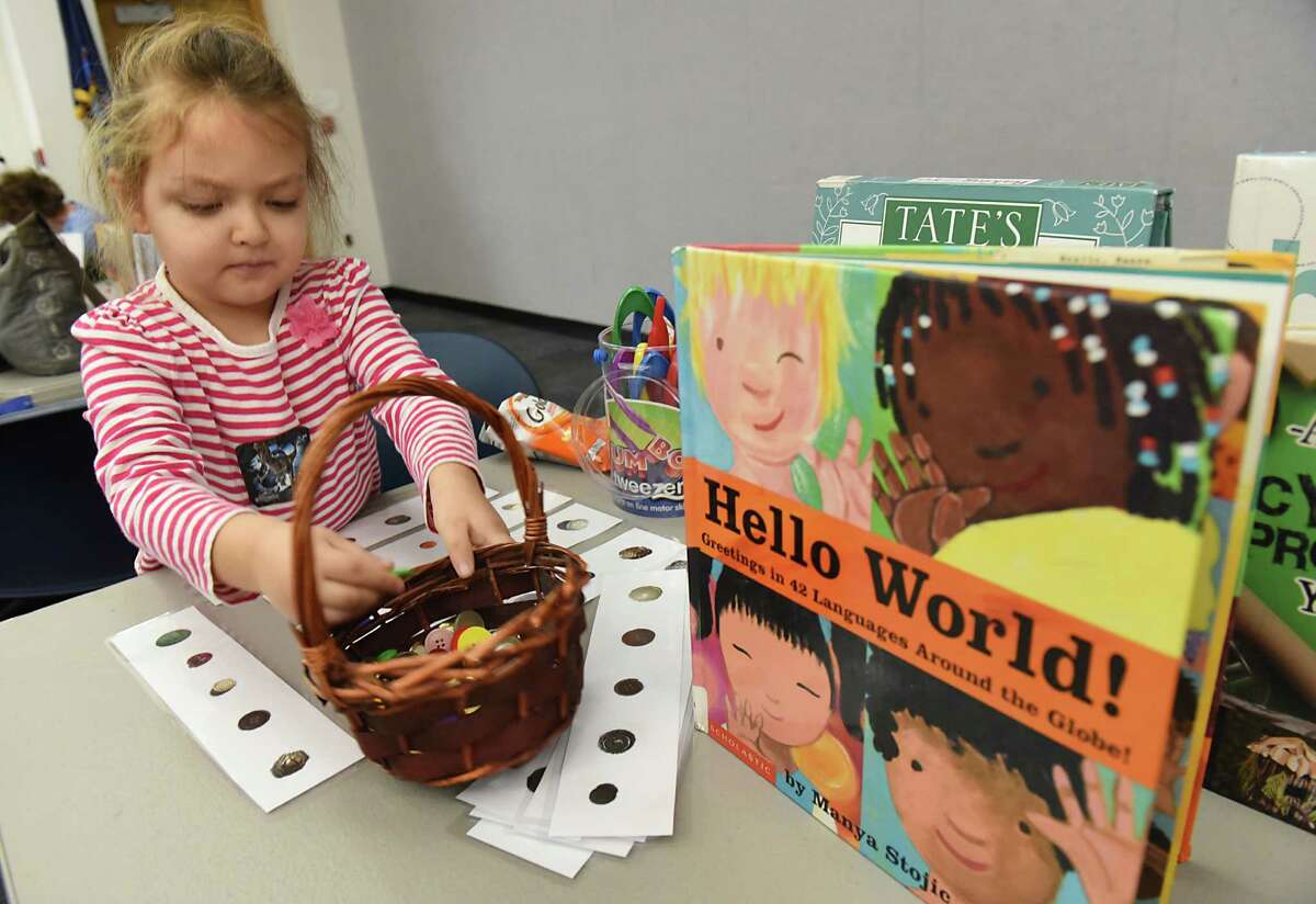 Amelia Tice, 5, of Guilderland works on a exercise where she places the same size and color buttons on a strip of paper with pictures of buttons during the "All Aboard to 1,000 Books Before Kindergarten!" event at Guilderland Public Library on Friday, Jan. 20, 2017 in Guilderland, N.Y. (Lori Van Buren / Times Union)