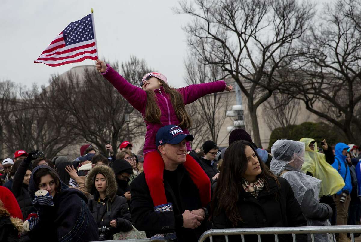 A girl waves an American flag at the National Mall during the 58th presidential inauguration in Washington, D.C., U.S., on Friday, Jan. 20, 2017. Donald Trump will become the 45th president of the United States today, in a celebration of American unity for a country that is anything but unified. Photographer: Eric Thayer/Bloomberg