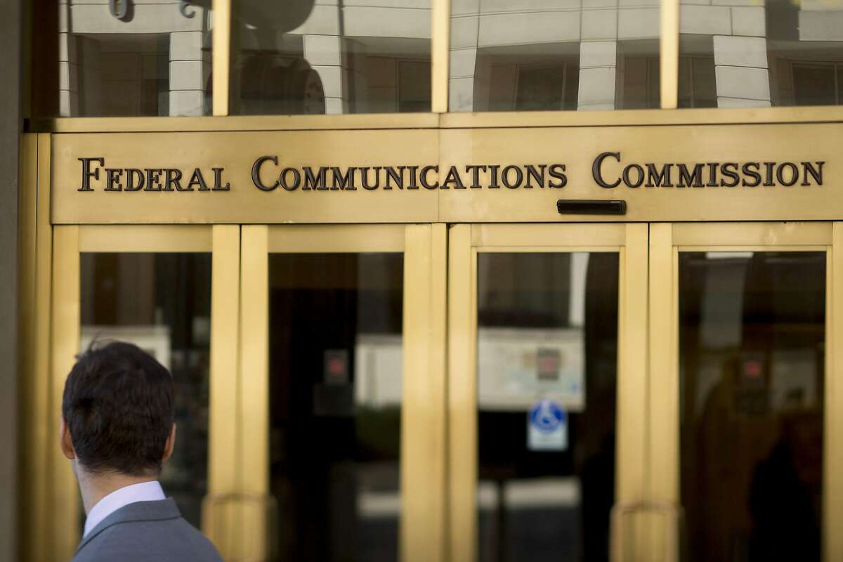 A man looks at the Federal Communications Commission (FCC) headquarters in this photo taken with a tilt-shift lens in Washington, D.C., U.S., on Monday, Nov. 10, 2014. President Barack Obama called for the "strongest possible rules" to protect the open Internet, advocating stricter controls than a regulator he appointed and causing shares of Comcast Corp. and other broadband providers to drop. Obama's comments tilt the White House against positions advocated by broadband providers and FCC Chairman Tom Wheeler. Photographer: Andrew Harrer/Bloomberg