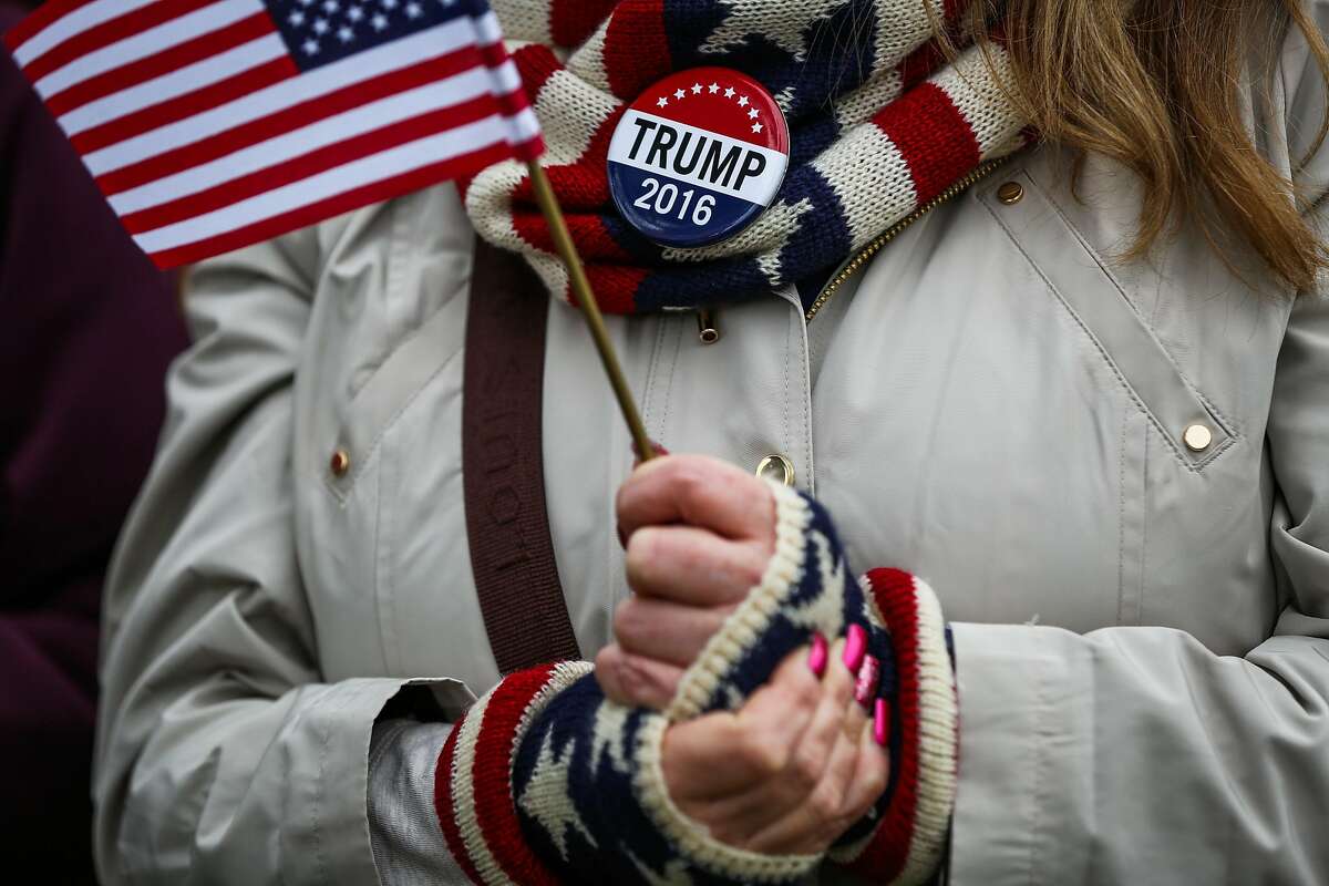 Trump supporter Michelle Orrell, of Delaware holds a flag as she watches Donald Trump being sworn in as President of The United States of America in Washington, D.C., on Friday, Jan. 20, 2017.