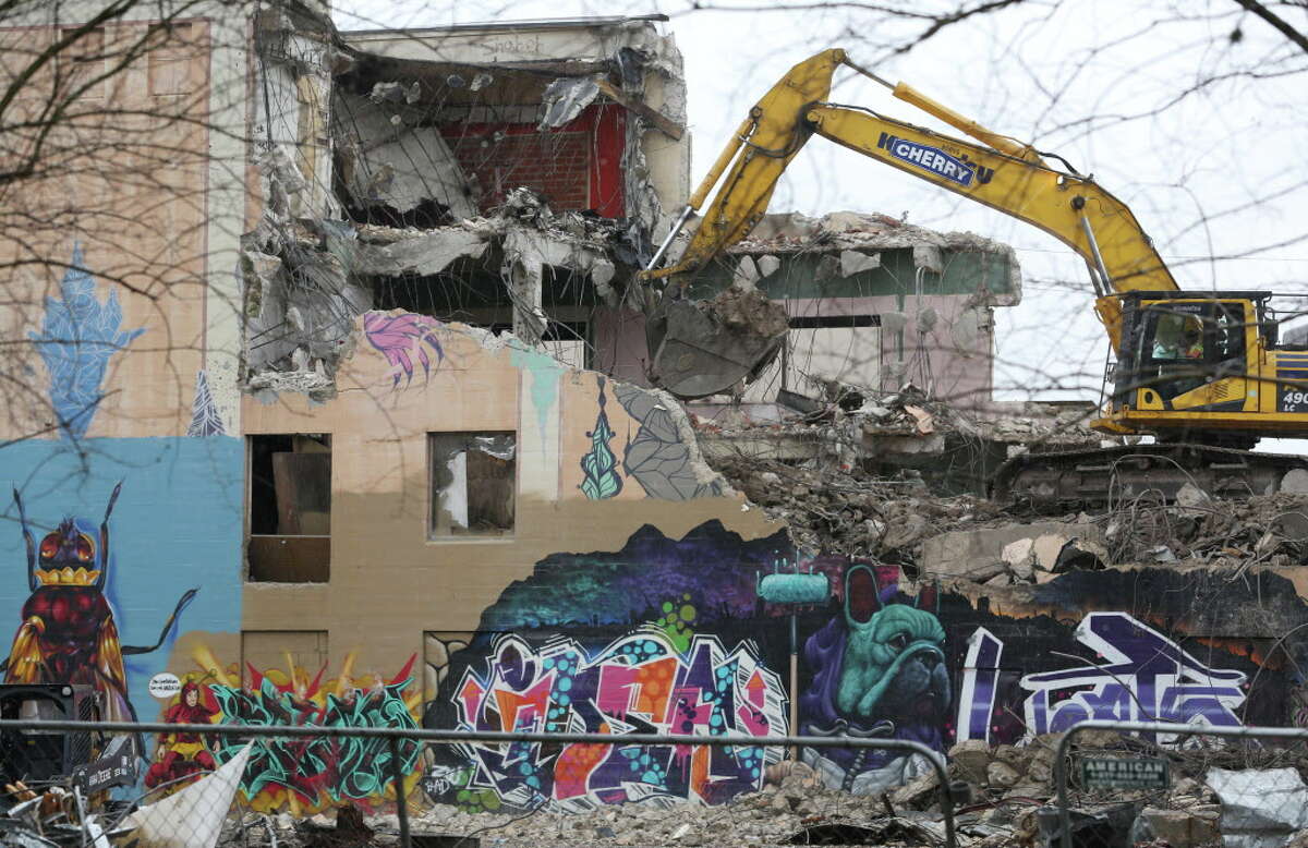 The abandoned former Mental Health and Mental Retardation Authority building, which has became a popular site fore murals and graffiti, in Midtown is being demolished Thursday, Jan. 19, 2017, in Houston. The majority of the building has been taken down, the block facing Tuam Street is the only side left as of Thursday morning. The construction crews said the entire structure should be demolished by the end of Friday. ( Yi-Chin Lee / Houston Chronicle )