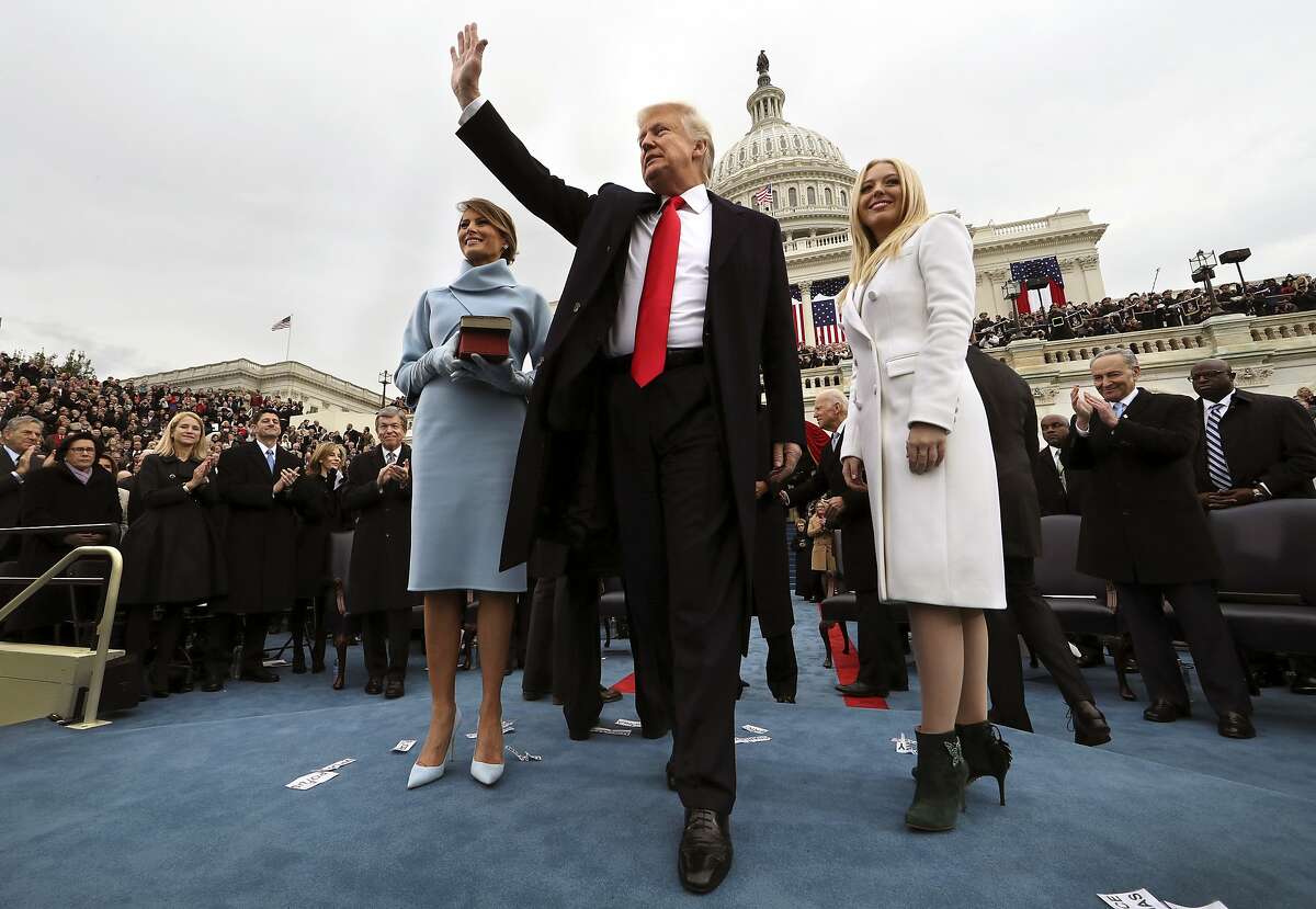 President Donald Trump waves after taking the oath of office as his wife Melania holds the Bible, and Tiffany Trump looks out to the crowd, Friday, Jan. 27, 2017 on Capitol Hill in Washington. (Jim Bourg/Pool Photo via AP)