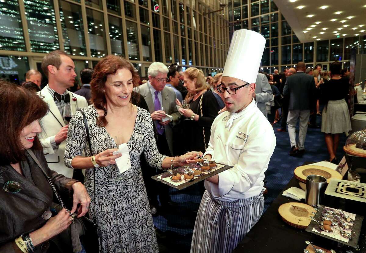 Maurizio Ferrarese, executive chef at Quattro at the Four Seasons, left, offers truffles to Susan Backes, center, and Karen Kislingbury, left, at Truffle Masters 2017, at the Hobby Center, Monday, Jan. 16, 2017, in Houston. ( Jon Shapley / Houston Chronicle )
