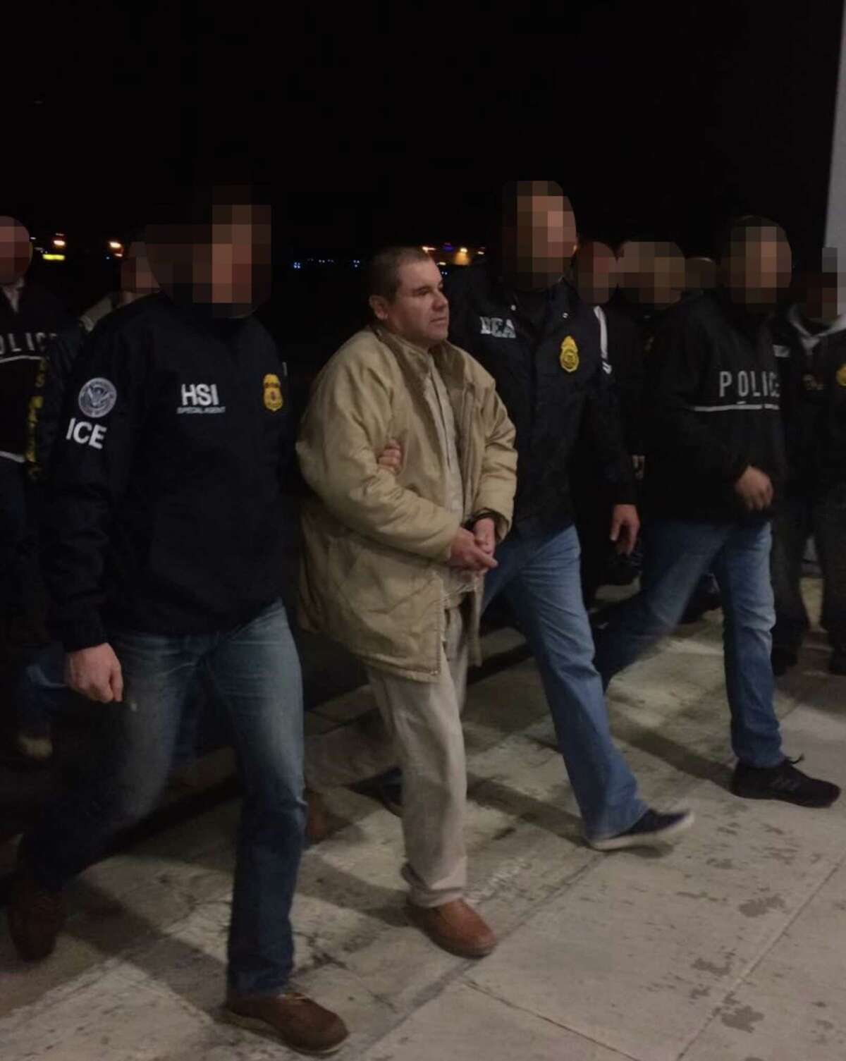 "El Chapo" Guzman is escorted by U.S. Immigration and Customs Enforcement personnel as he is extradited to the U.S. on Thursday. The ICE agents' faces were blurred intentionally.