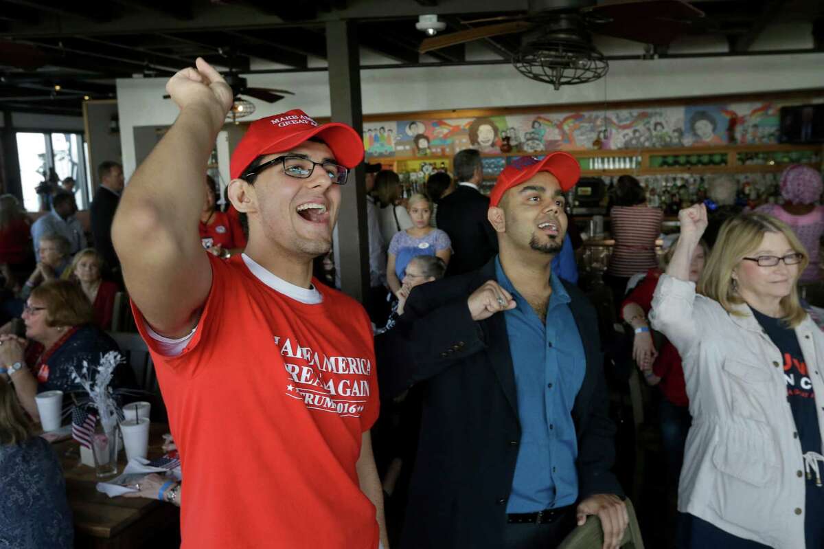 Asher Warriach, left, and Sonny Khatua, center, cheer during the GOP inaugural watch party at Ninfa's, 2704 Navigation Blvd., Friday, Jan. 20, 2017, in Houston. ( Melissa Phillip / Houston Chronicle )