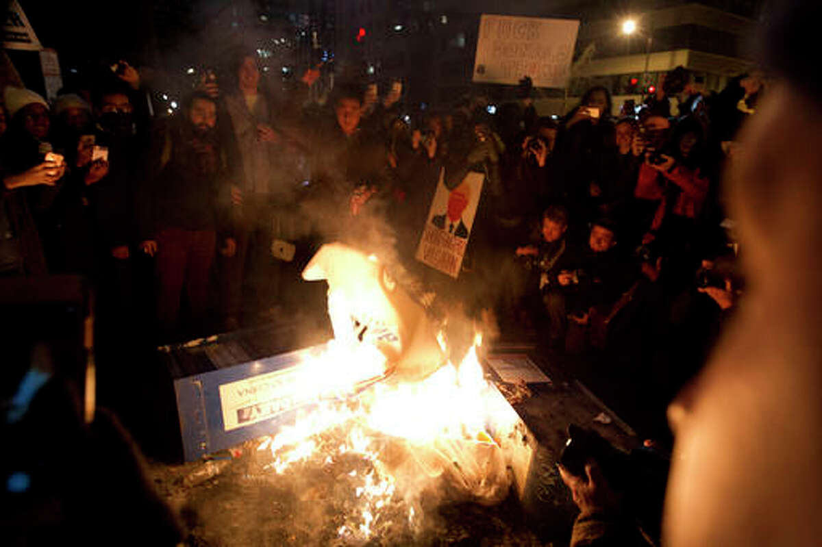 Demonstrators burn trash during the demonstration in, Washington Friday, Jan. 20, 2017, during the inauguration of President Donald Trump. ( AP Photo/Jose Luis Magana)