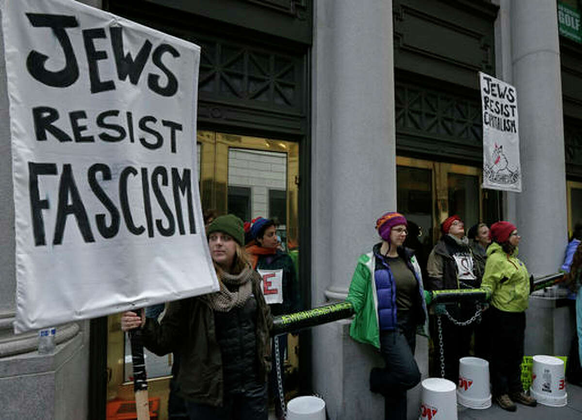 Anti-Trump protestors rally and chain themselves at the entrance of the Israeli consulate on Friday, Jan. 20, 2017, in San Francisco. Demonstrators gathered in the rain Friday at San Francisco's Civic Center Plaza and across the bay in Oakland at the Ronald Dellums Federal Building. (AP Photo/Ben Margot)