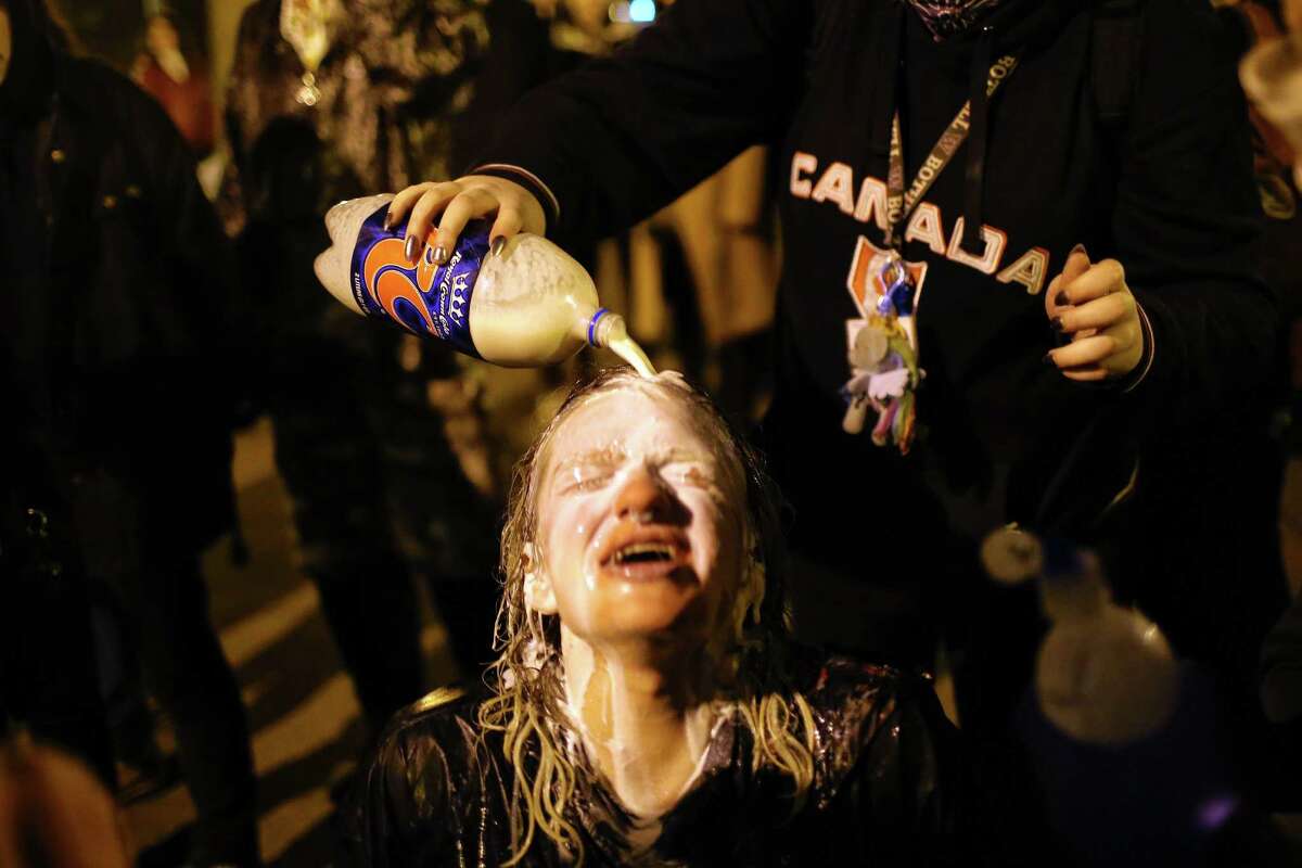 A young woman's eyes are washed out with milk after she is sprayed with pepper spray by police. Protesters and police clashed at the school as Milo Yiannopoulos spoke inside. One man in the crowd was shot as supporters and opponents of the Breitbart.com editor waited to see if they would be able to attend his talk there.