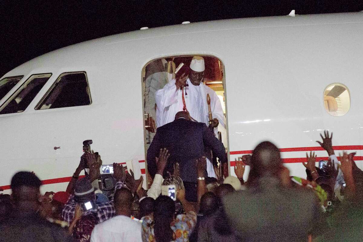 Gambia's defeated leader Yahya Jammeh waves to supporters as he departs at Banjul airport Saturday Jan. 21, 2017. Jammeh announced early Saturday he has decided to relinquish power, after hours of last-ditch talks with regional leaders and the threat by a regional military force to make him leave. (AP Photo/Jerome Delay)