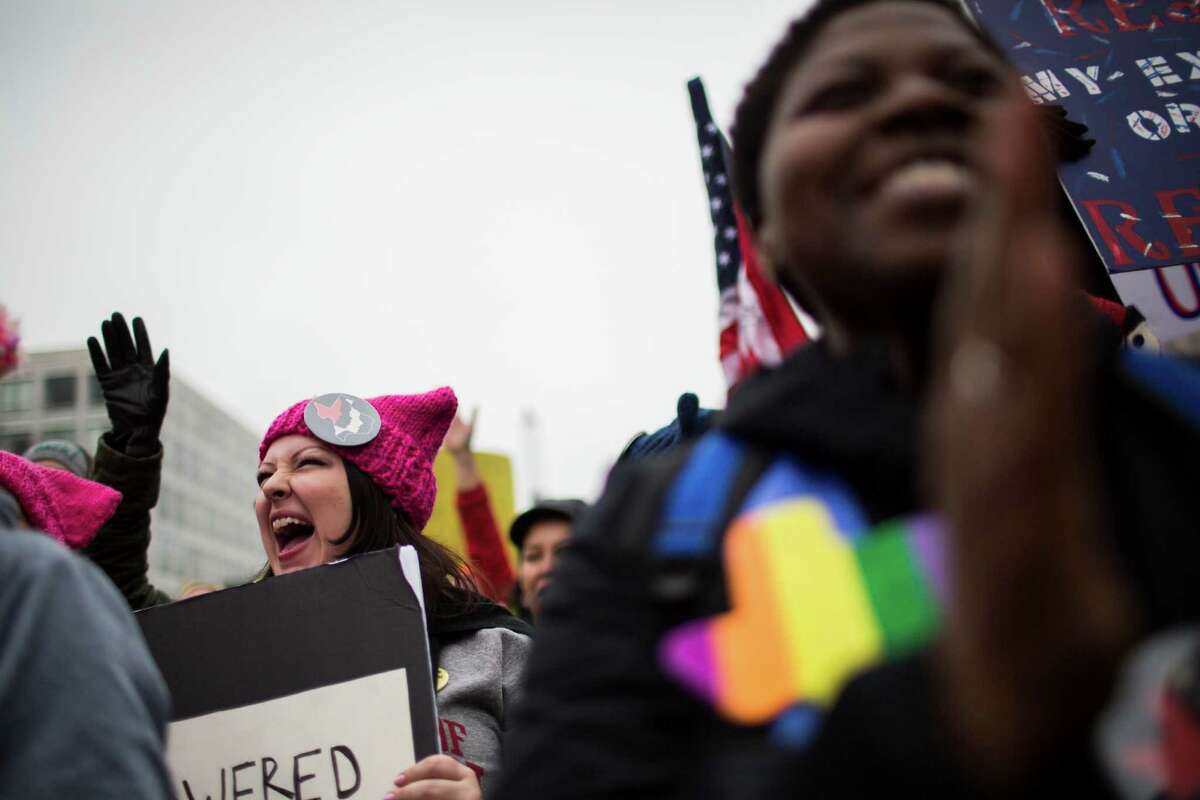 Houstonians Randi Waller, left, 32, and Ursula Johnson, 37, cheer Saturday during speeches at the Women's March in Washington, D.C.