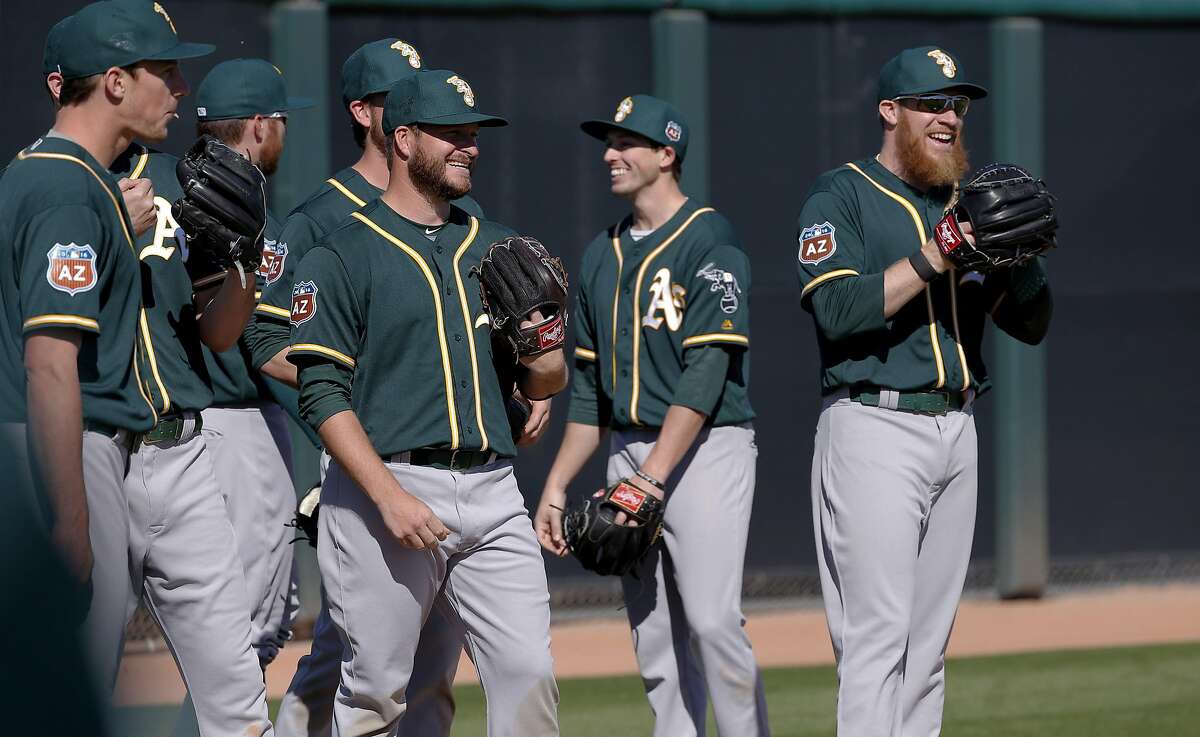Sean Doolittle, 62 (right) and fellow pitchers share a laugh during spring training workouts for the Oakland Athletics at the Lew Wolff Training Complex in Mesa, Arizona on Thurs. February 25, 2016.